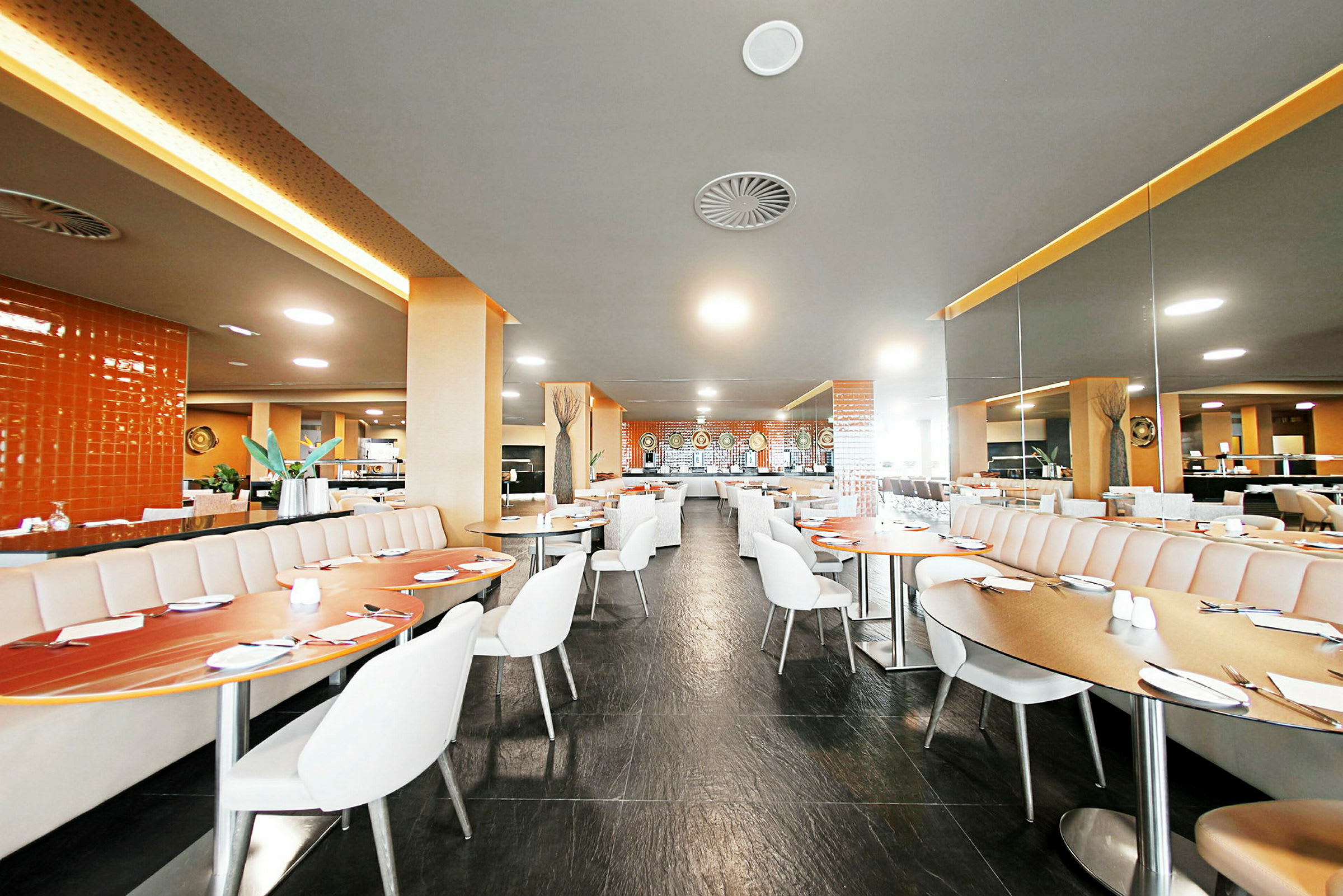 En modern och ljus restaurang med sittplatser och bord. (AI-genererad text)