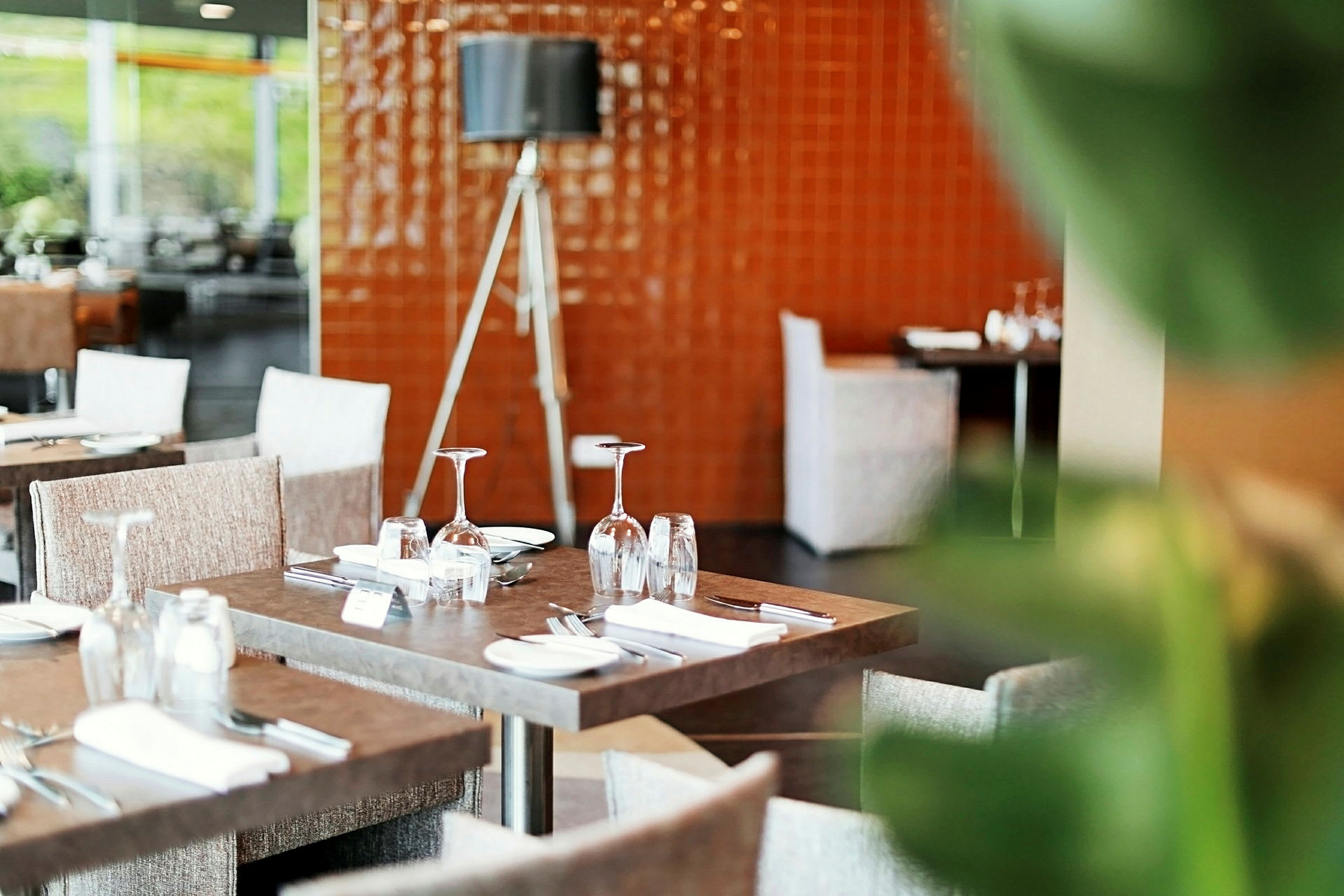 En restaurang med dukade bord och sittplatser. (AI-genererad text)