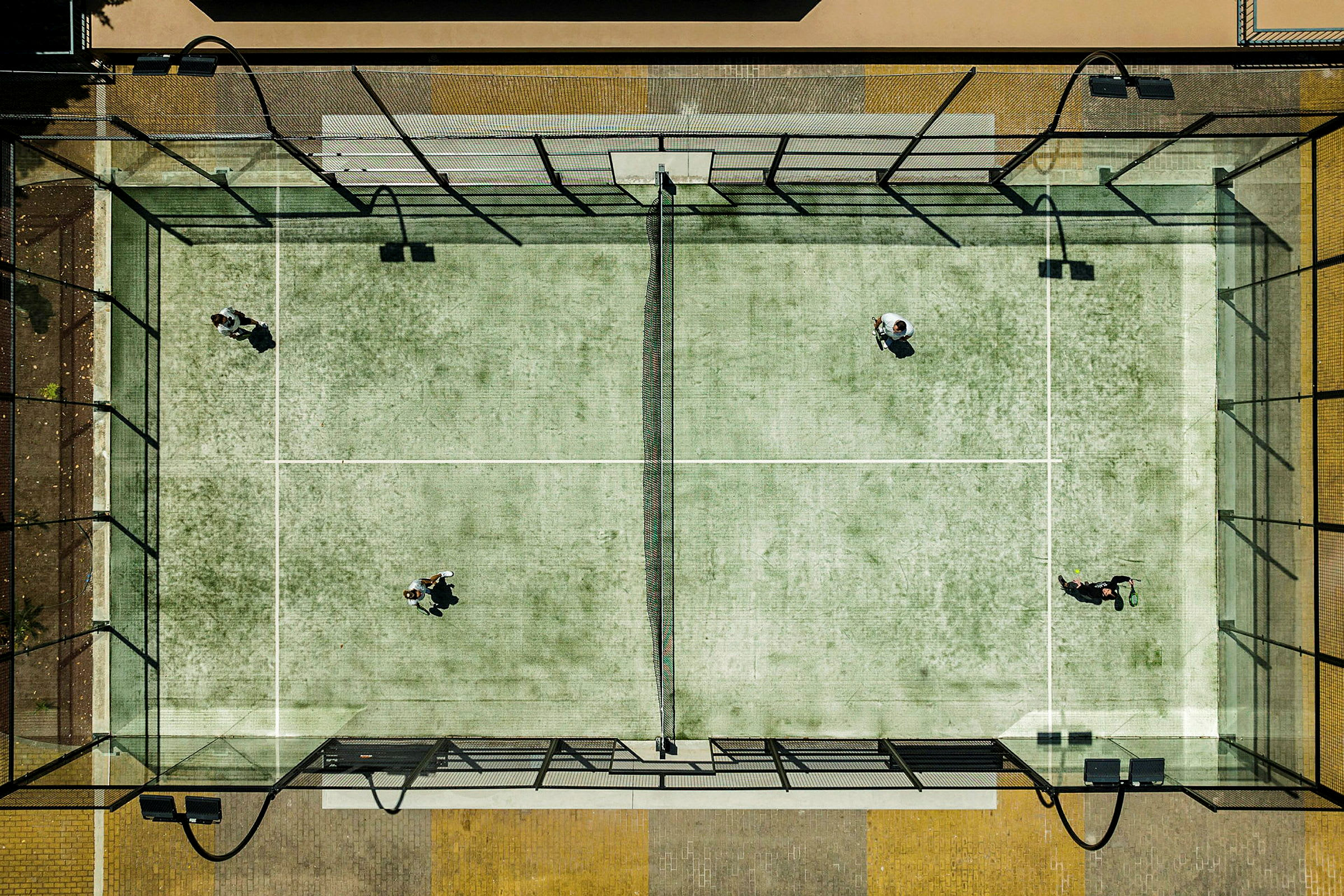 Luftvy av en padelbana med fyra personer som spelar. (AI-genererad text)