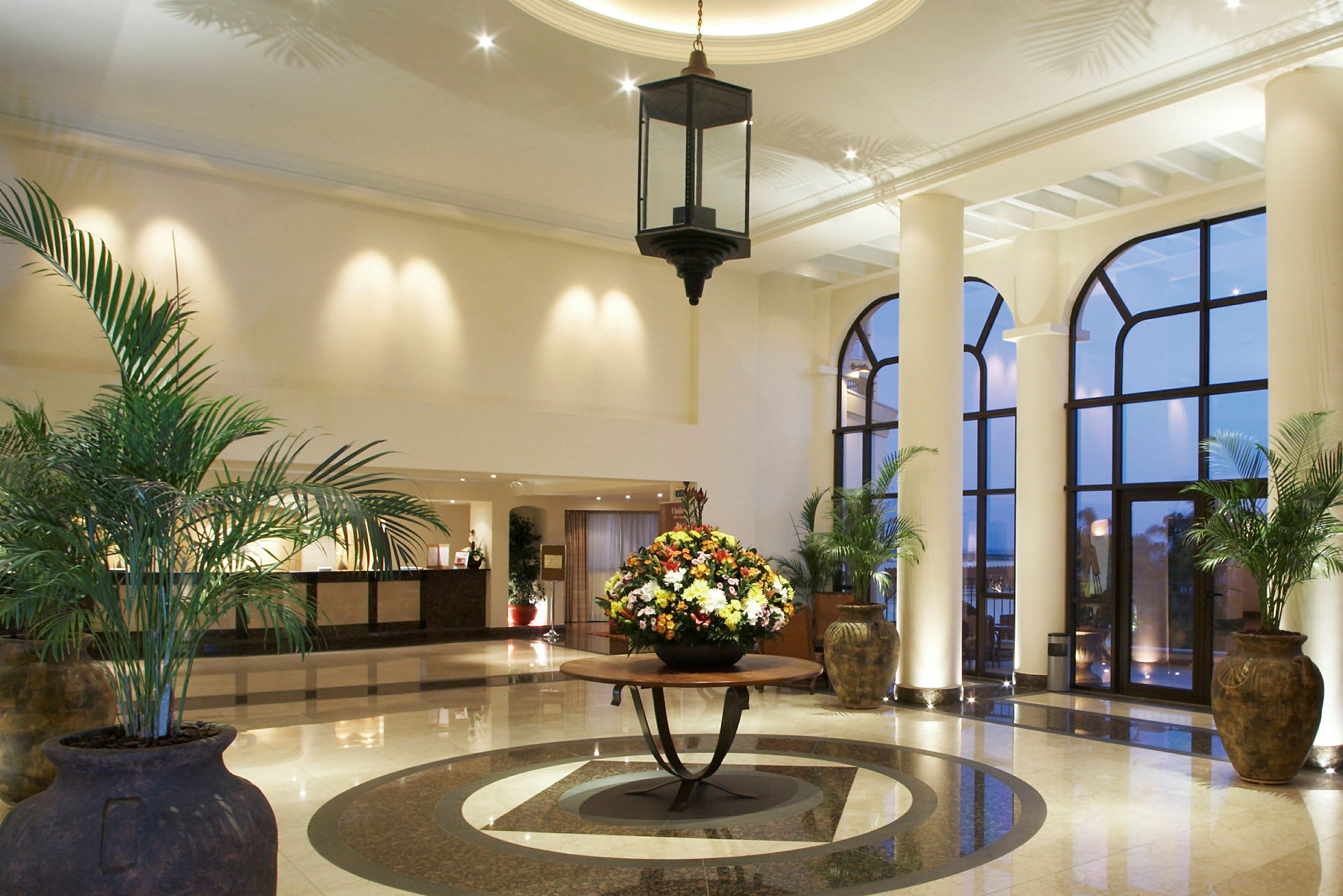 Hotellobby med stora fönster och prydnadsväxter. (AI-genererad text)
