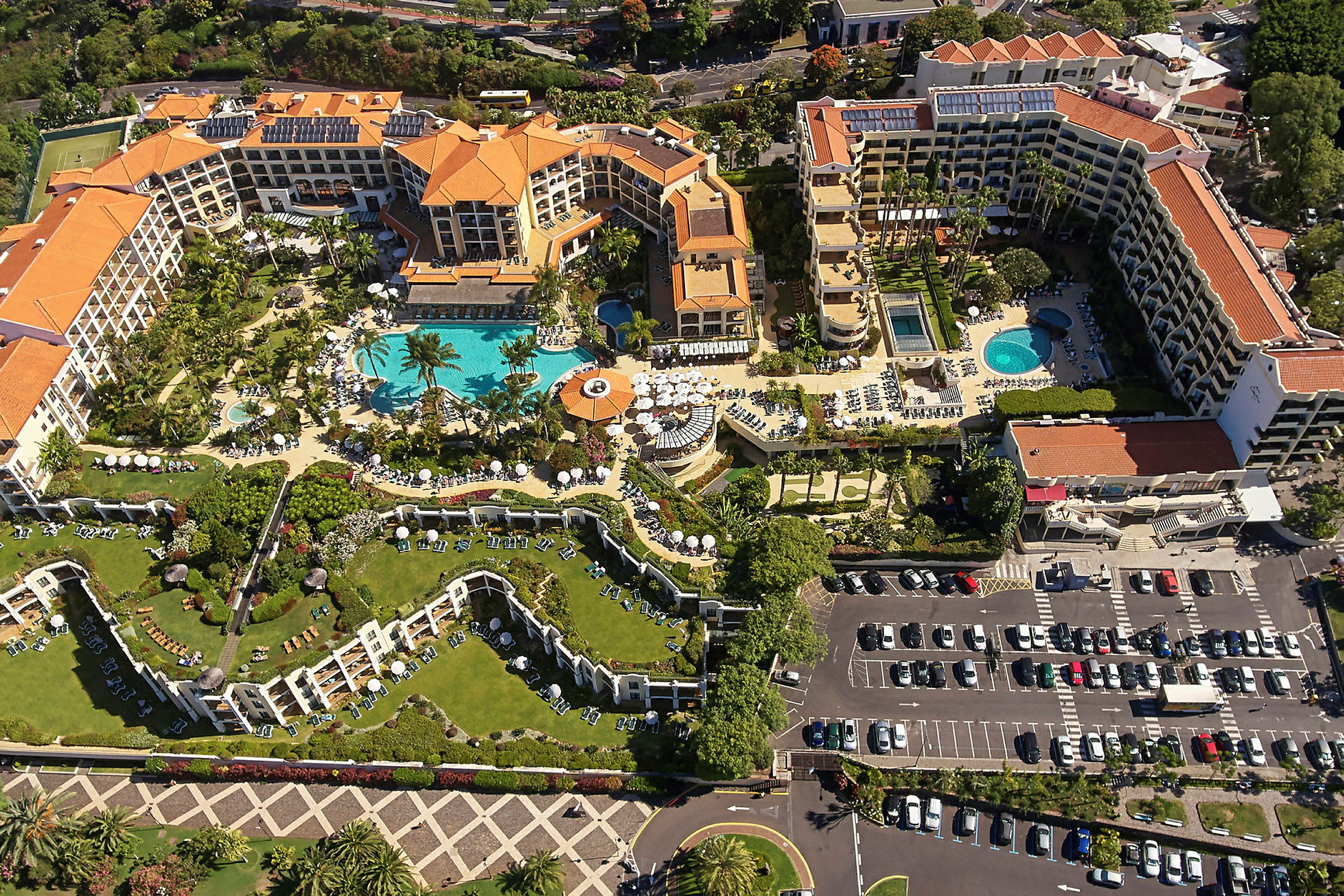 Flygfoto av ett hotellkomplex med pooler och grönområden. (AI-genererad text)