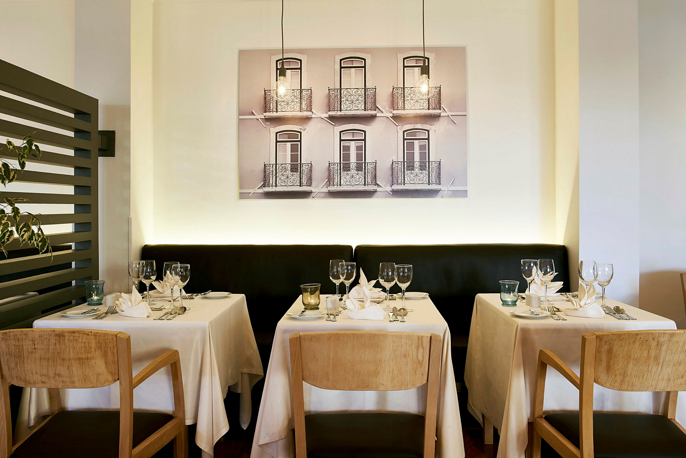 Restaurangområde med uppdukade bord med vita dukar och trästolar. (AI-genererad text)