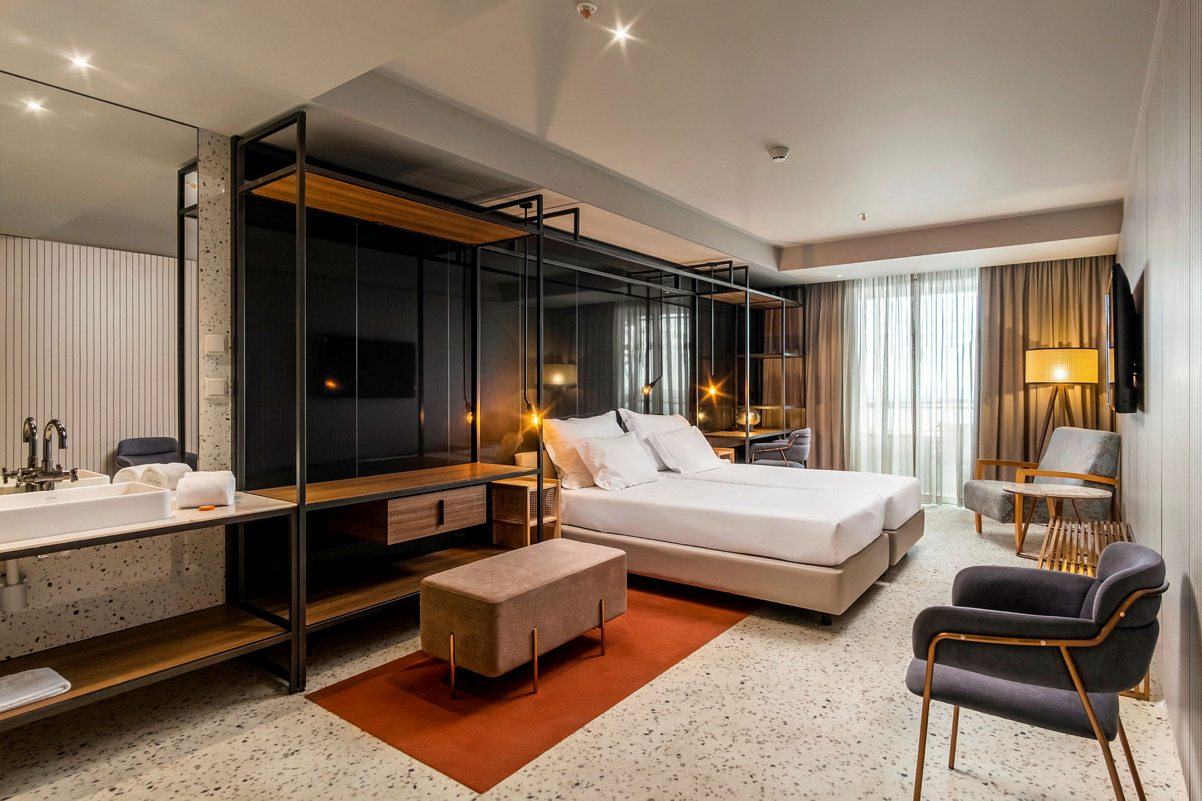 Modernt hotellrum med dubbelsäng, sittgrupp och skrivbord. (AI-genererad text)
