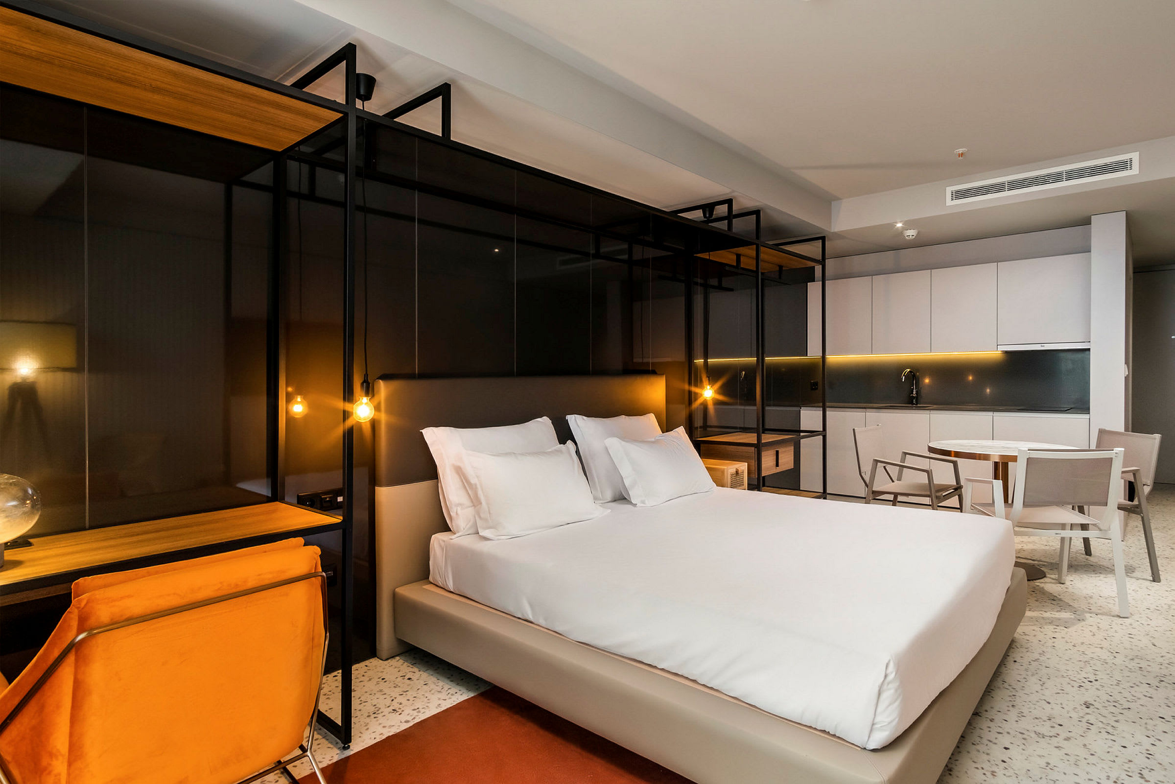 Modernt inredd hotellrum med en dubbelsäng, skrivbord och sittmöbler. (AI-genererad text)