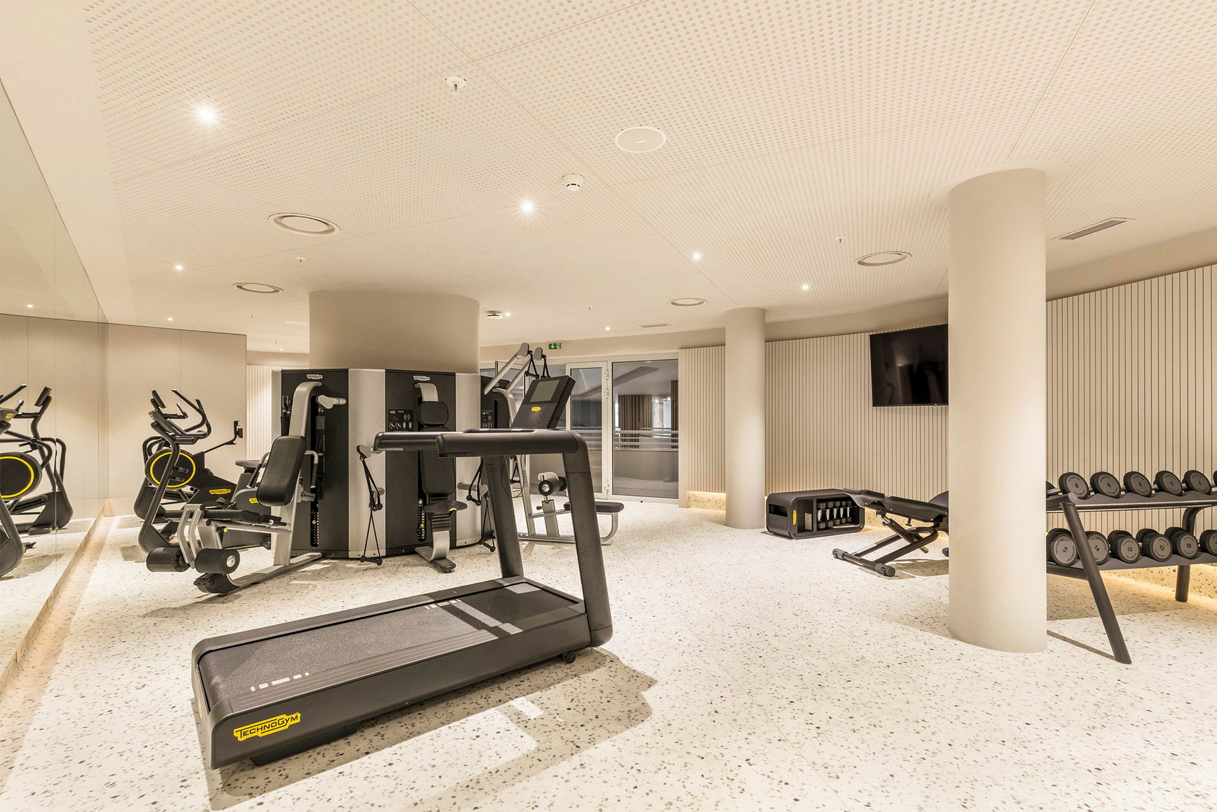Ett modernt gym med träningsmaskiner, löpband och vikter. (AI-genererad text)