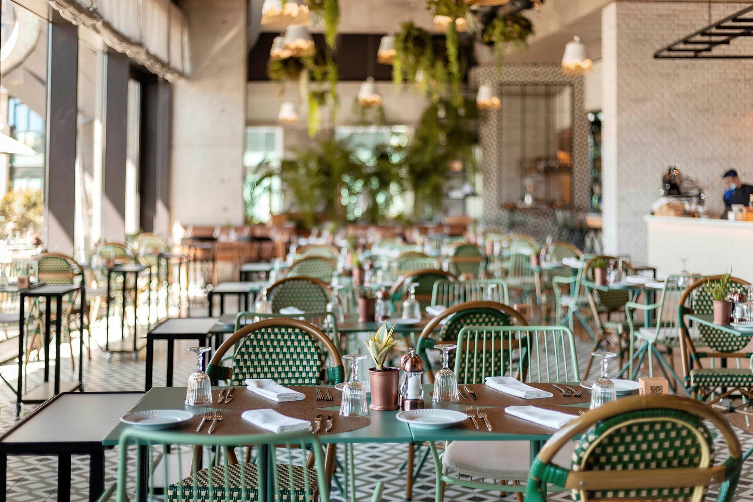 Interiör av en restaurang med dukade bord och stolar. (AI-genererad text)
