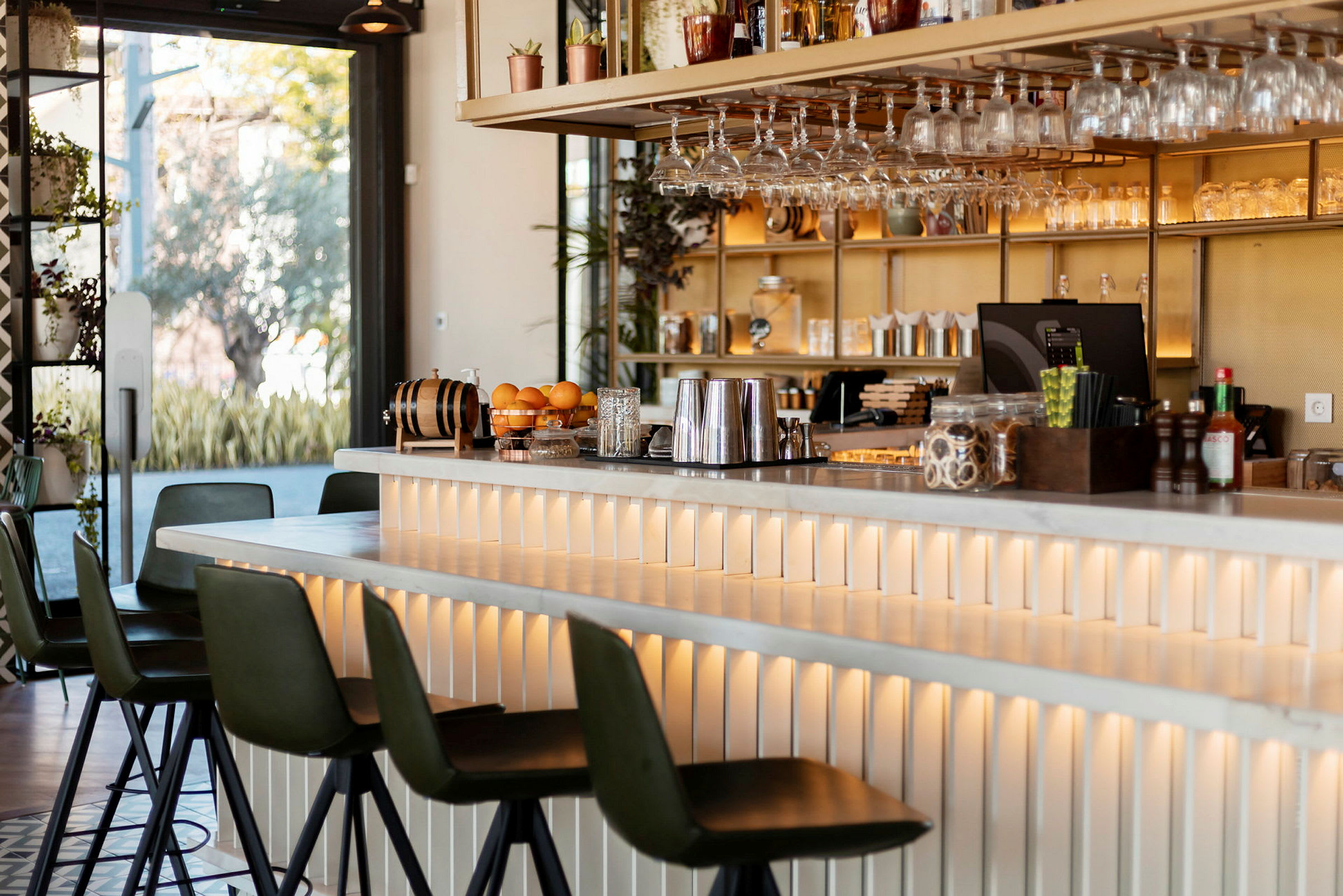 En bar med sittplatser, glas och dryckestillbehör. (AI-genererad text)