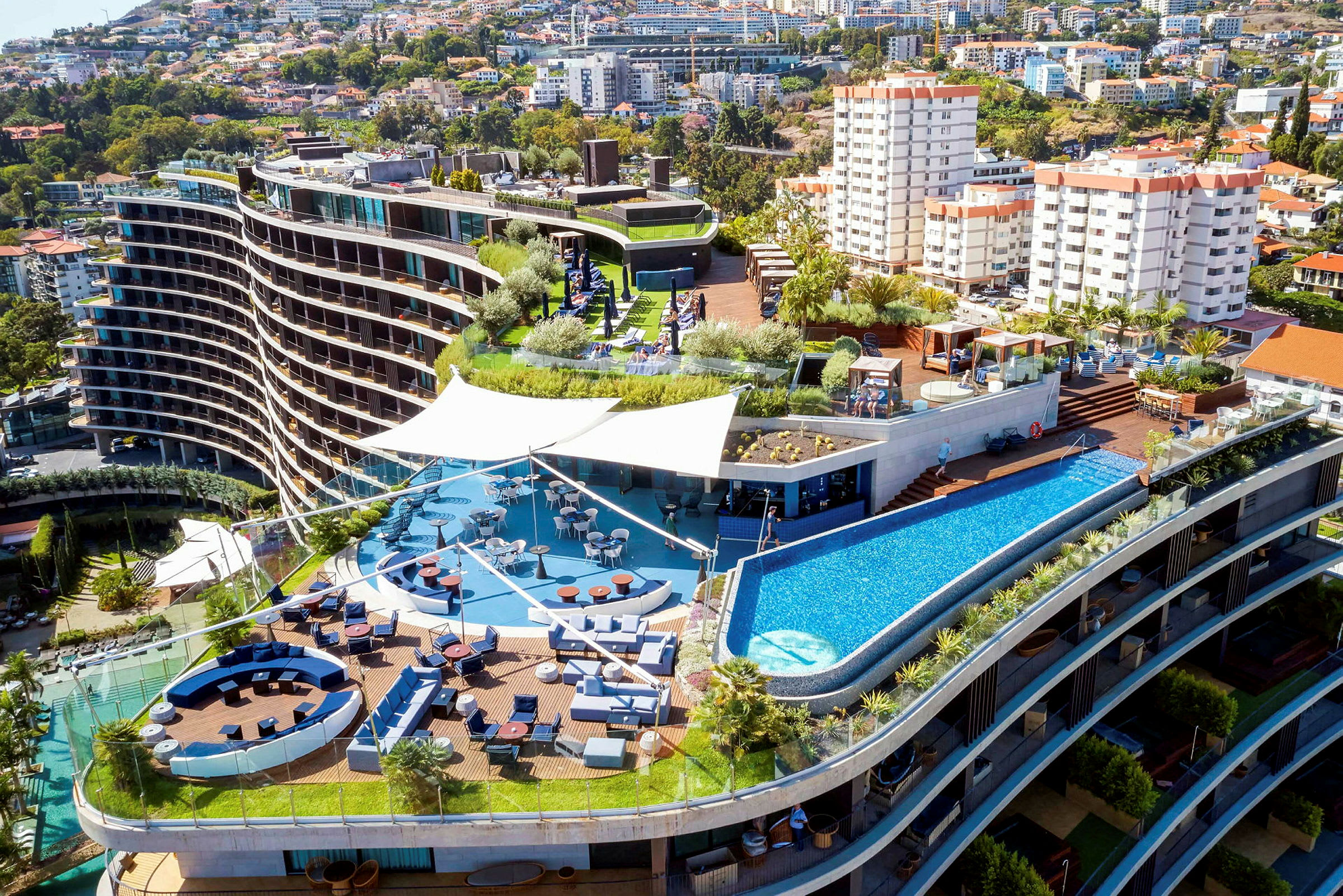 Hotellkomplex med terrass, pool och sittgrupper. (AI-genererad text)