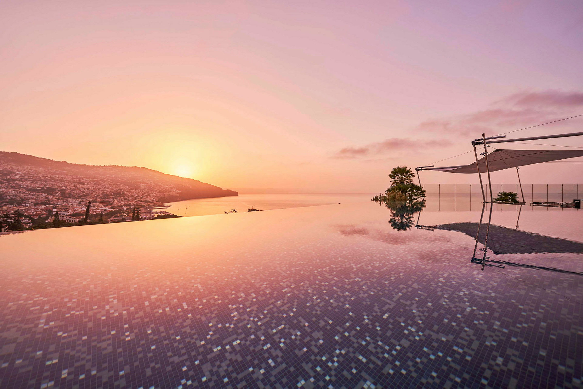 Infinitypool med utsikt över staden och havet vid solnedgången. (AI-genererad text)