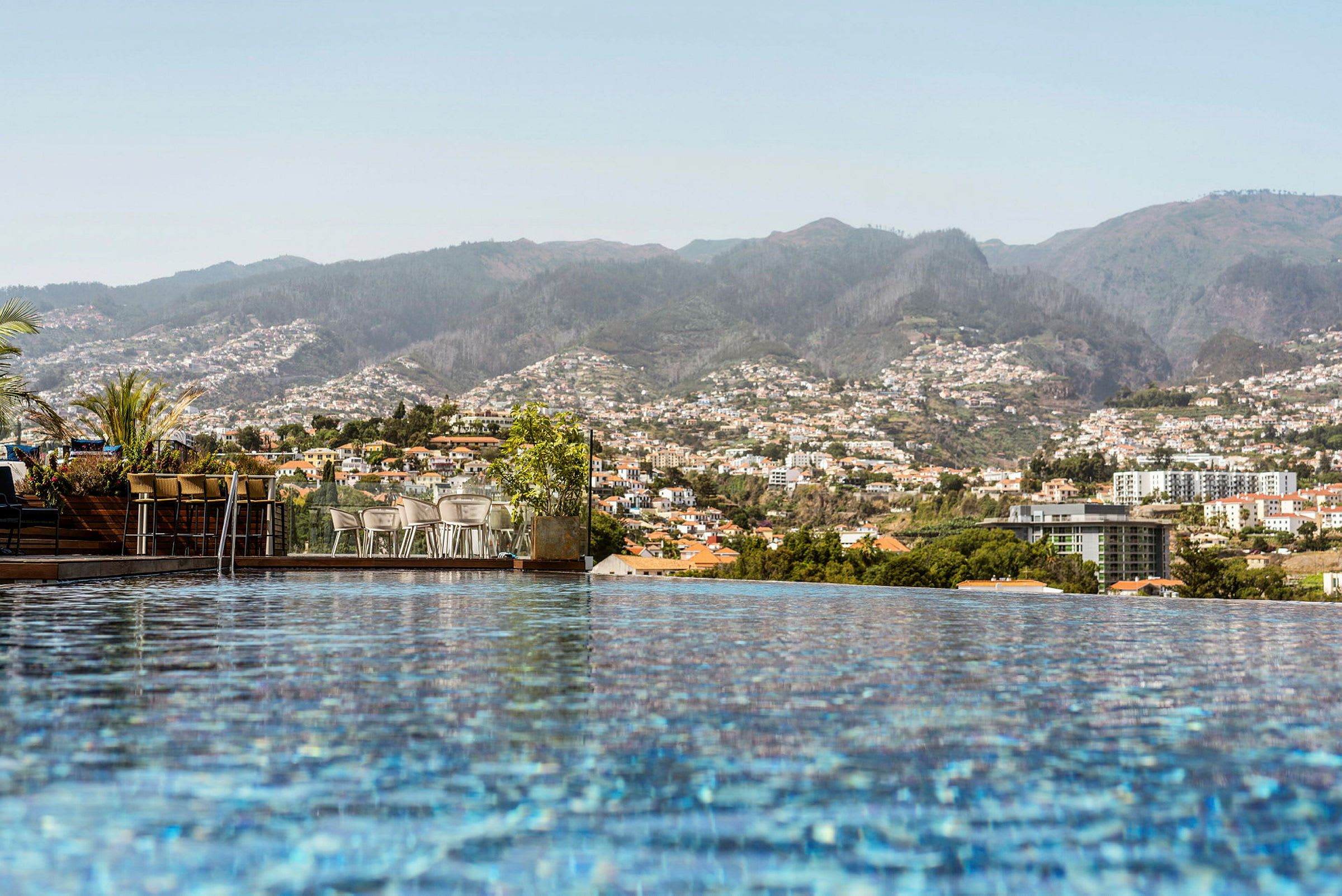 Utsikt över en stad med berg i bakgrunden, fotograferad från en pool. (AI-genererad text)