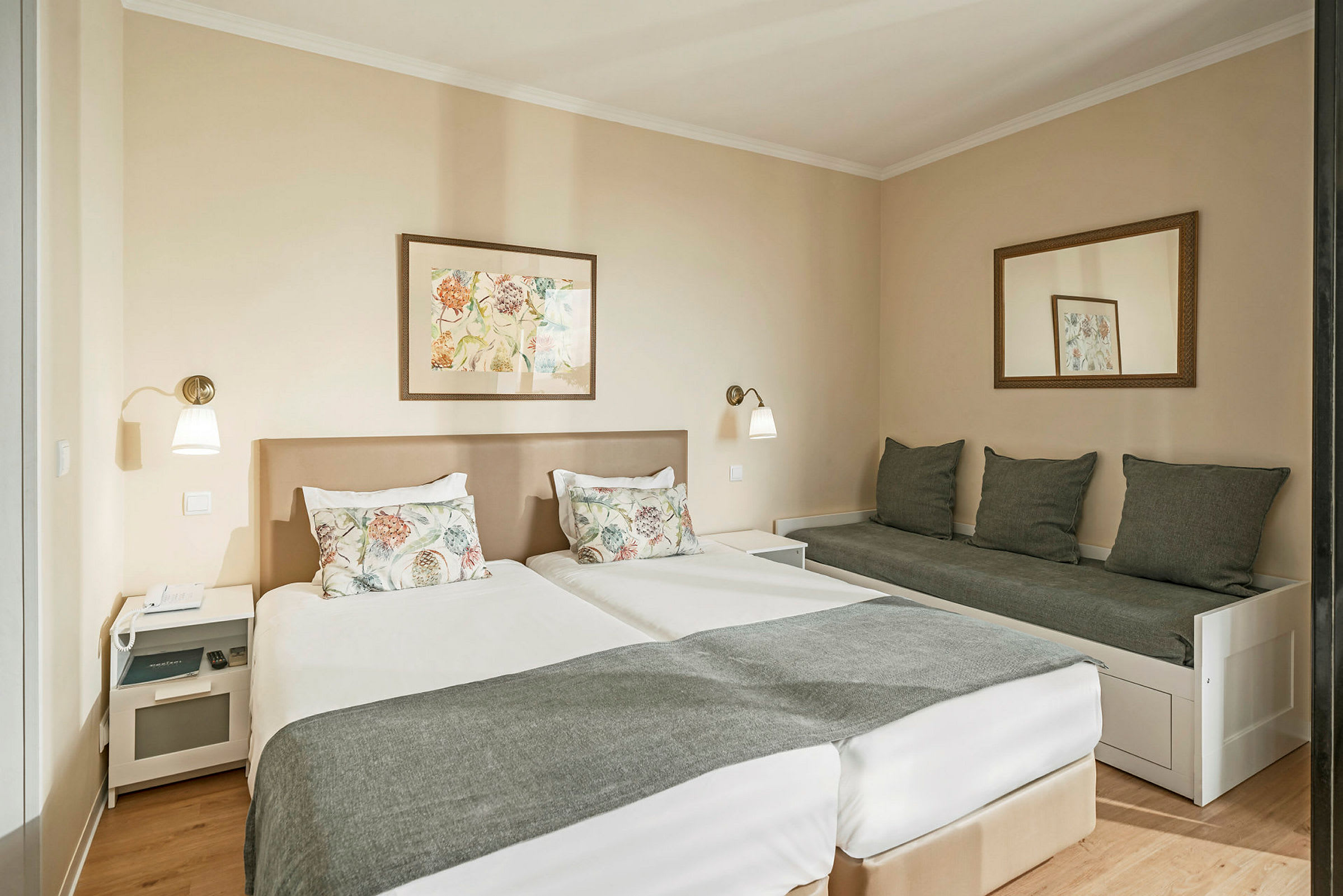 Ett hotellrum med två sängar och en soffa bredvid. (AI-genererad text)