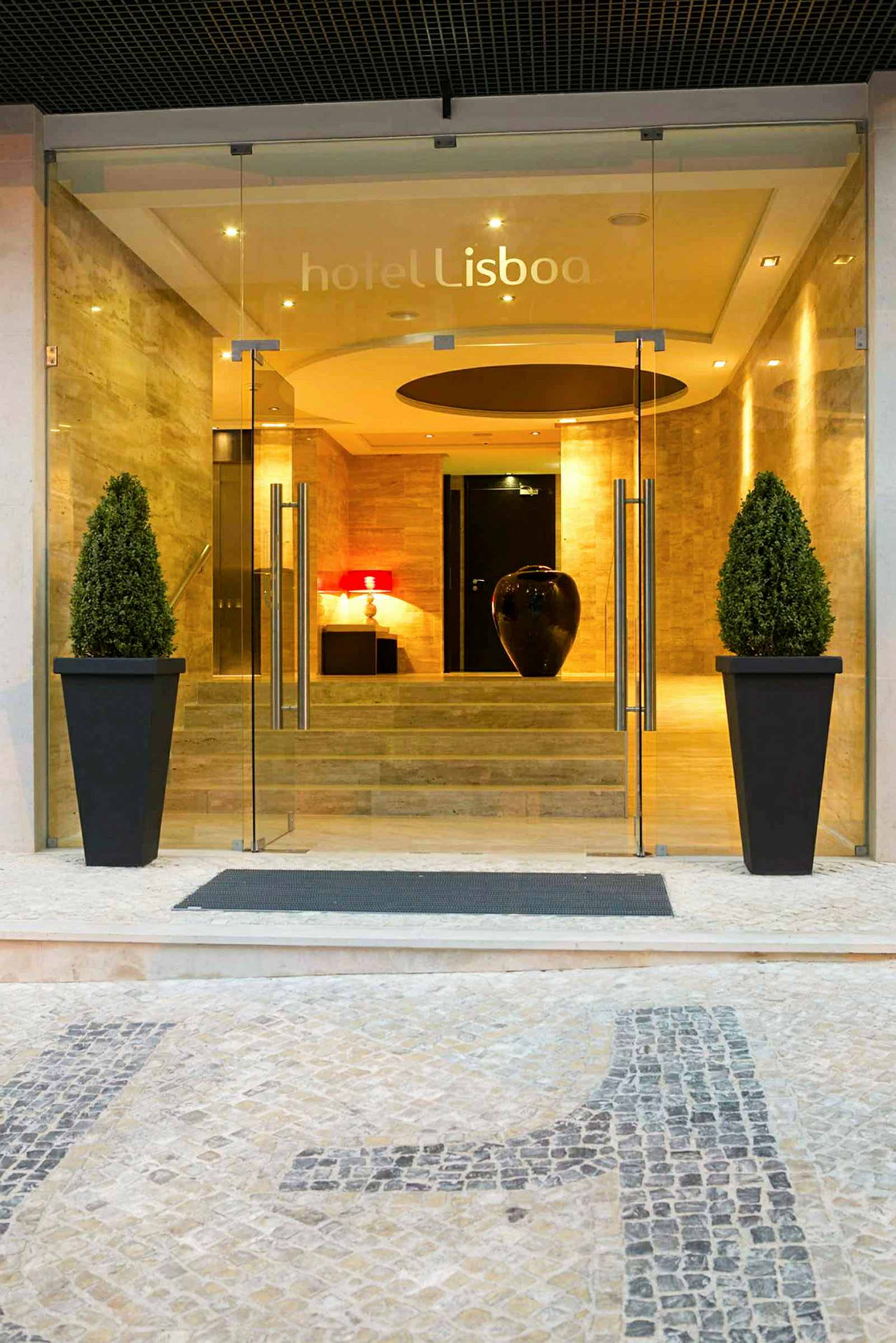 Ingången till hotellet Lisboa med glasdörrar och dekorationer. (AI-genererad text)