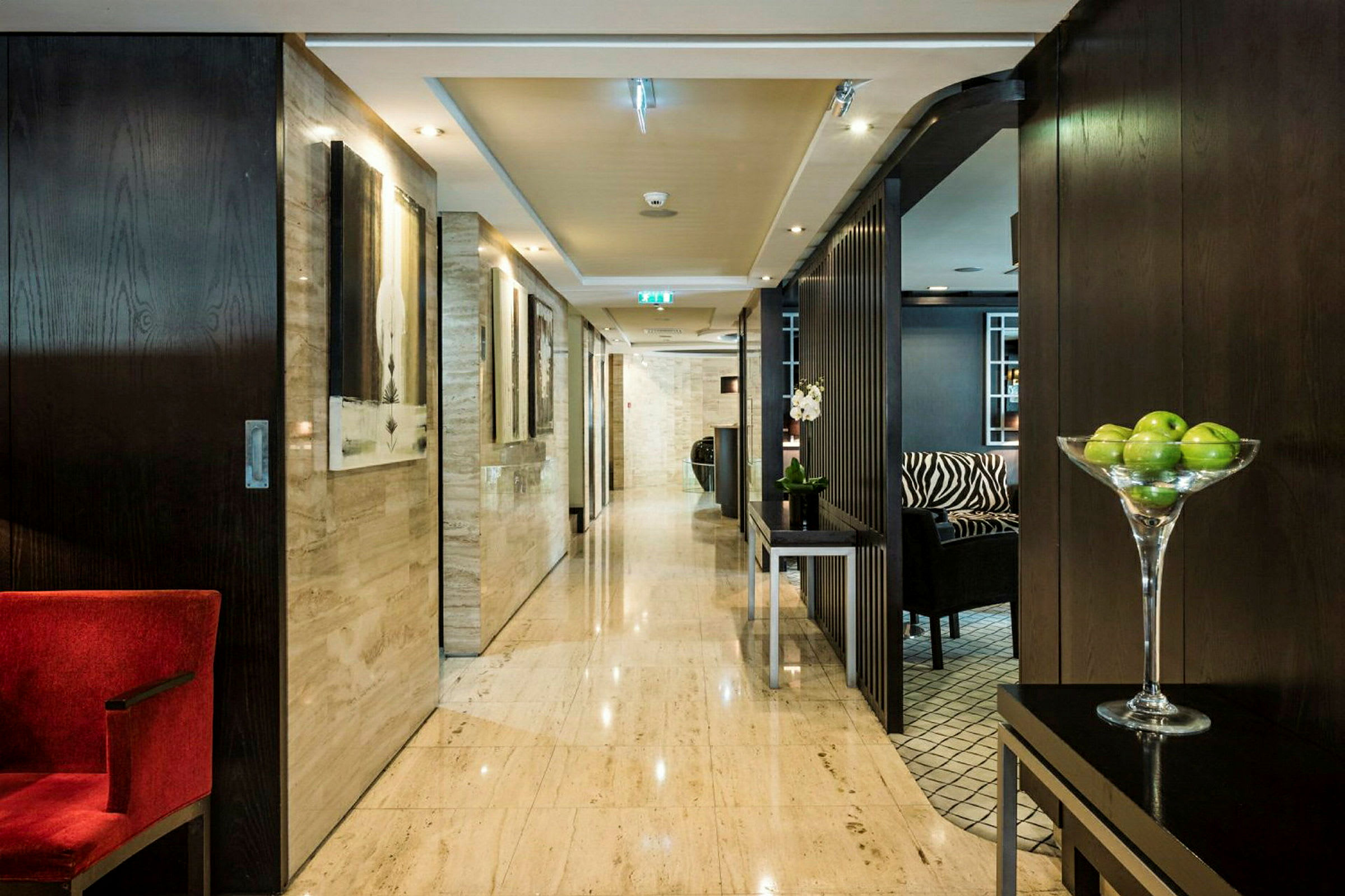 Hotellkorridor med modern inredning och gröna äpplen i en skål. (AI-genererad text)