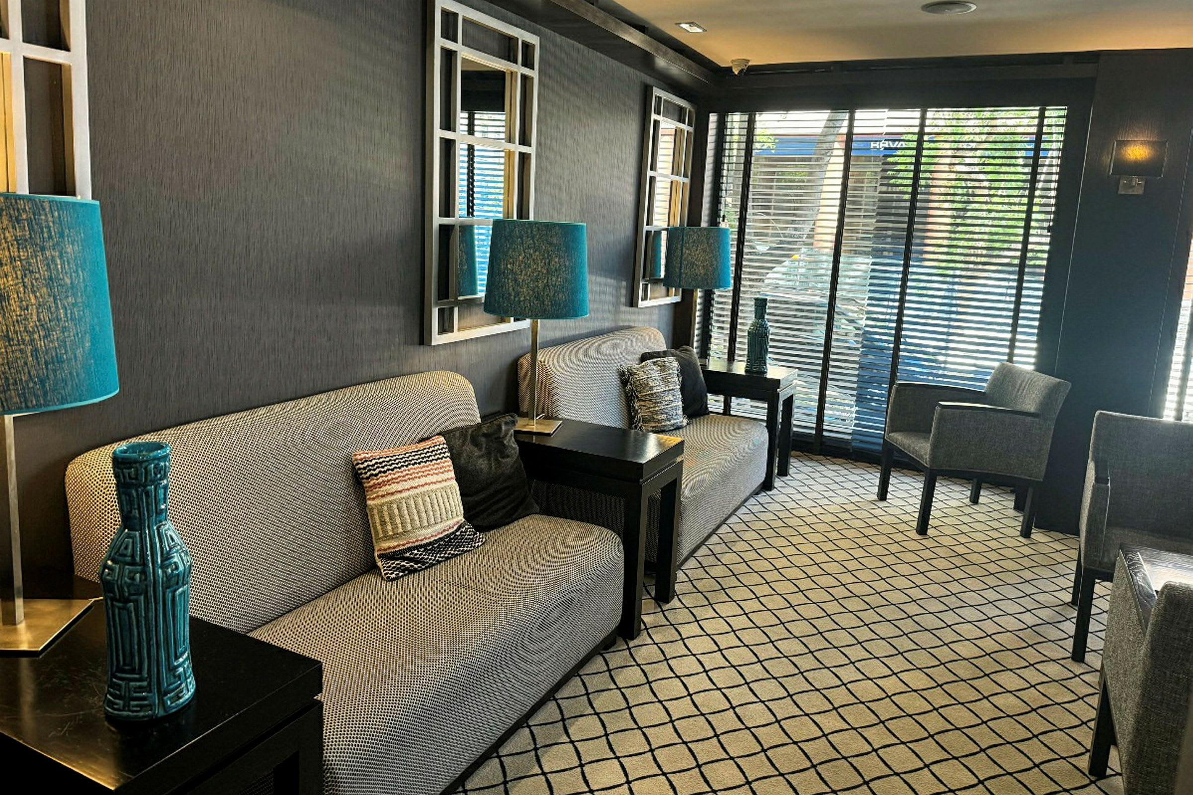 En hotellobby med soffor, blå lampor, och moderna detaljer. (AI-genererad text)