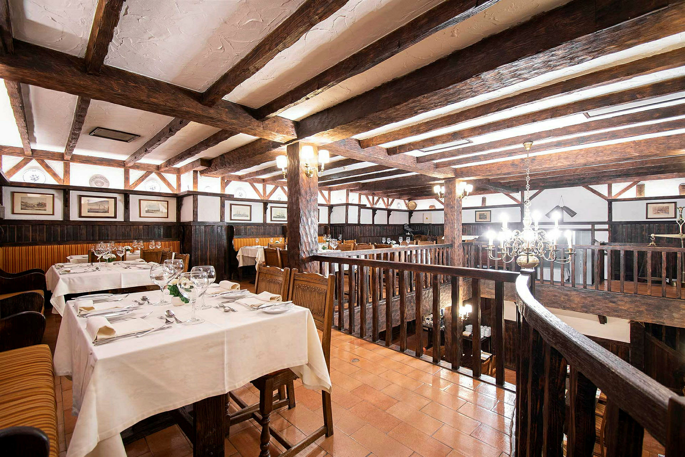 Rustik restaurang med träbjälkar och dukade bord. (AI-genererad text)