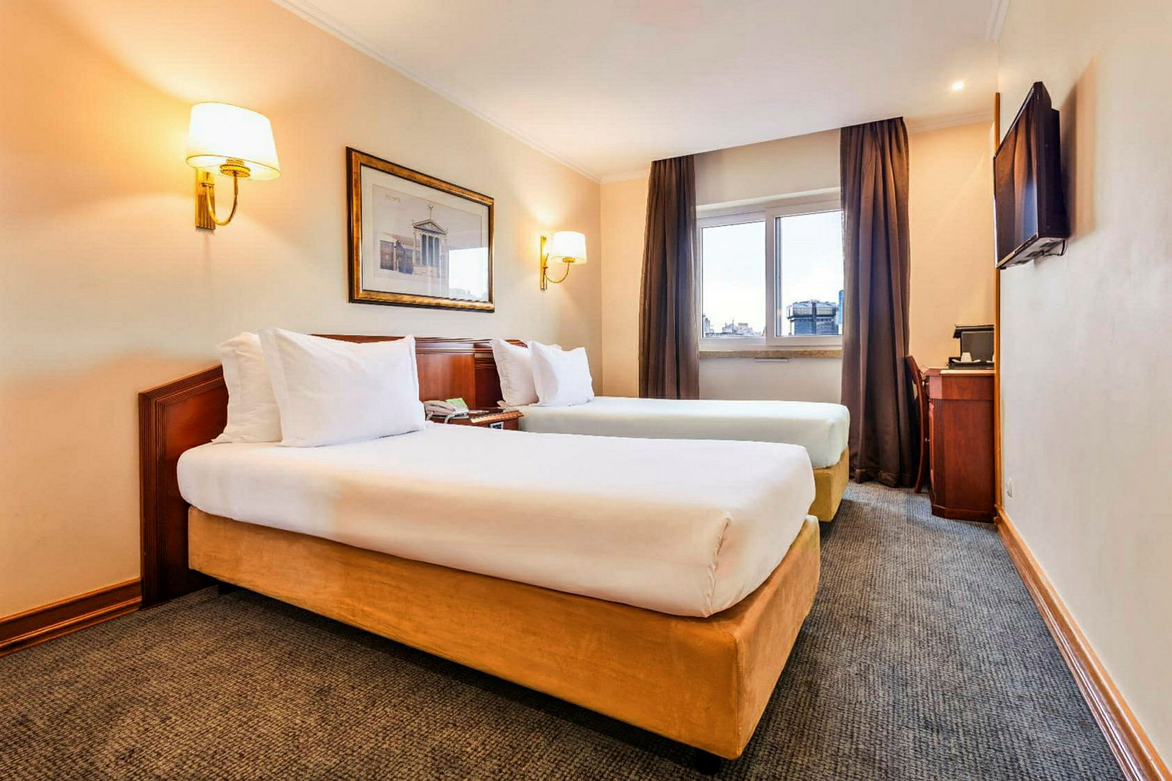 Bild av en hotellrum med två enkelsängar, ett fönster med gardiner, en väggmålning, och ett skrivbord med en stol. (AI-genererad text)