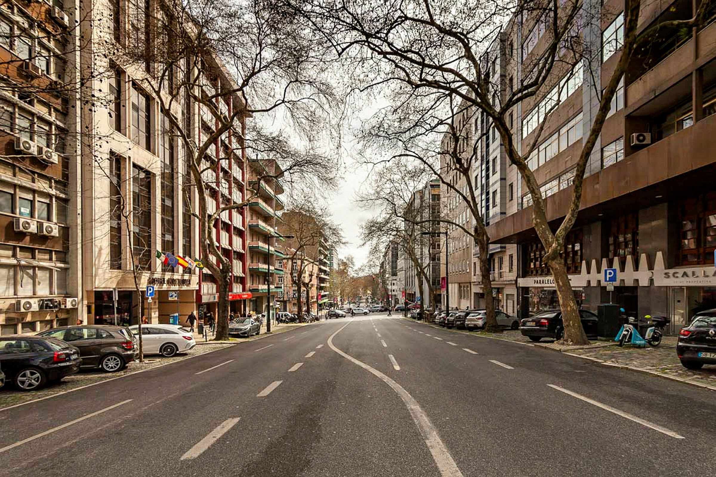 En bild av en tom stadsgata kantad av byggnader och träd. (AI-genererad text)