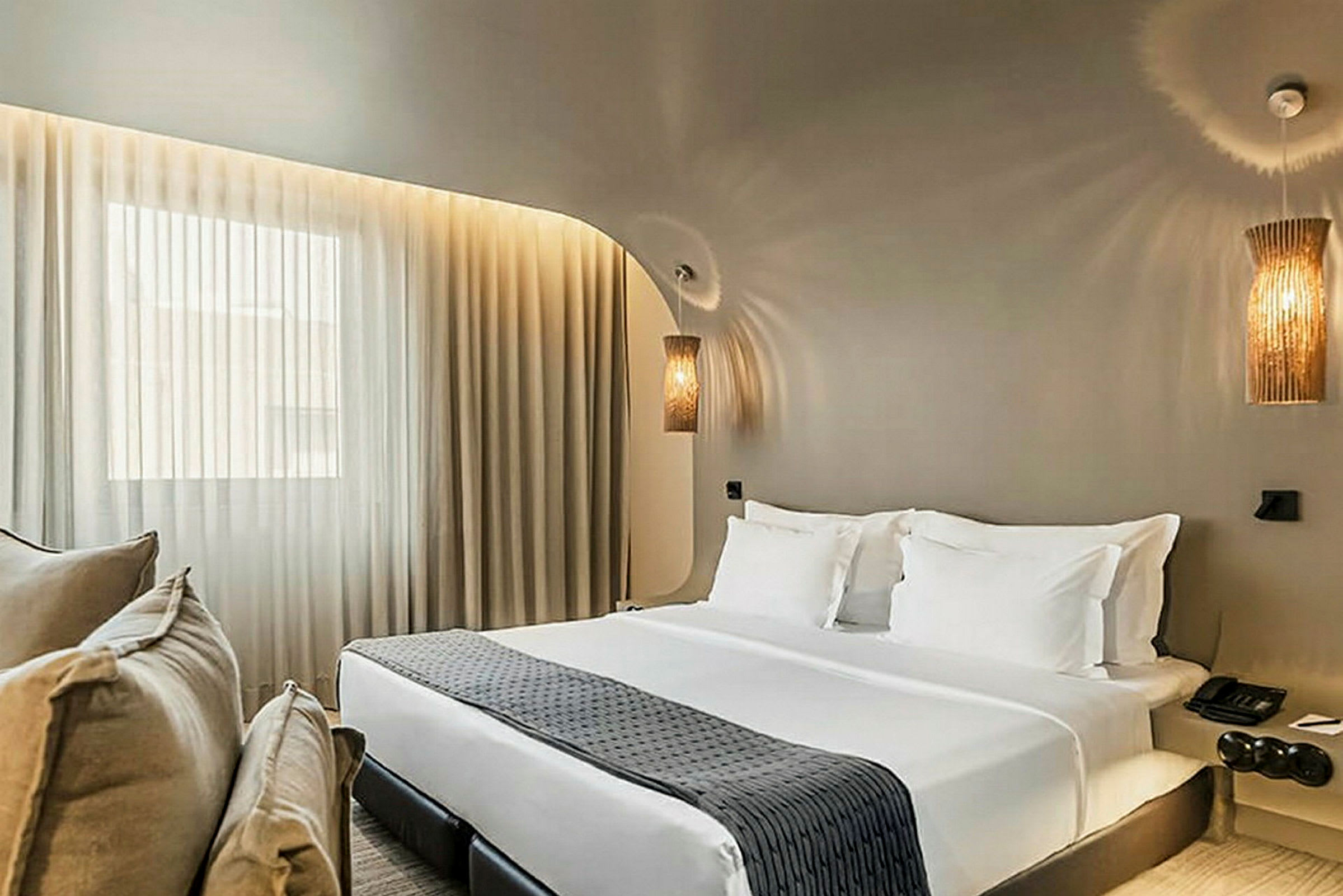 Hotellrum med dubbelsäng, vita sängkläder och dekorativa sänglampor. (AI-genererad text)