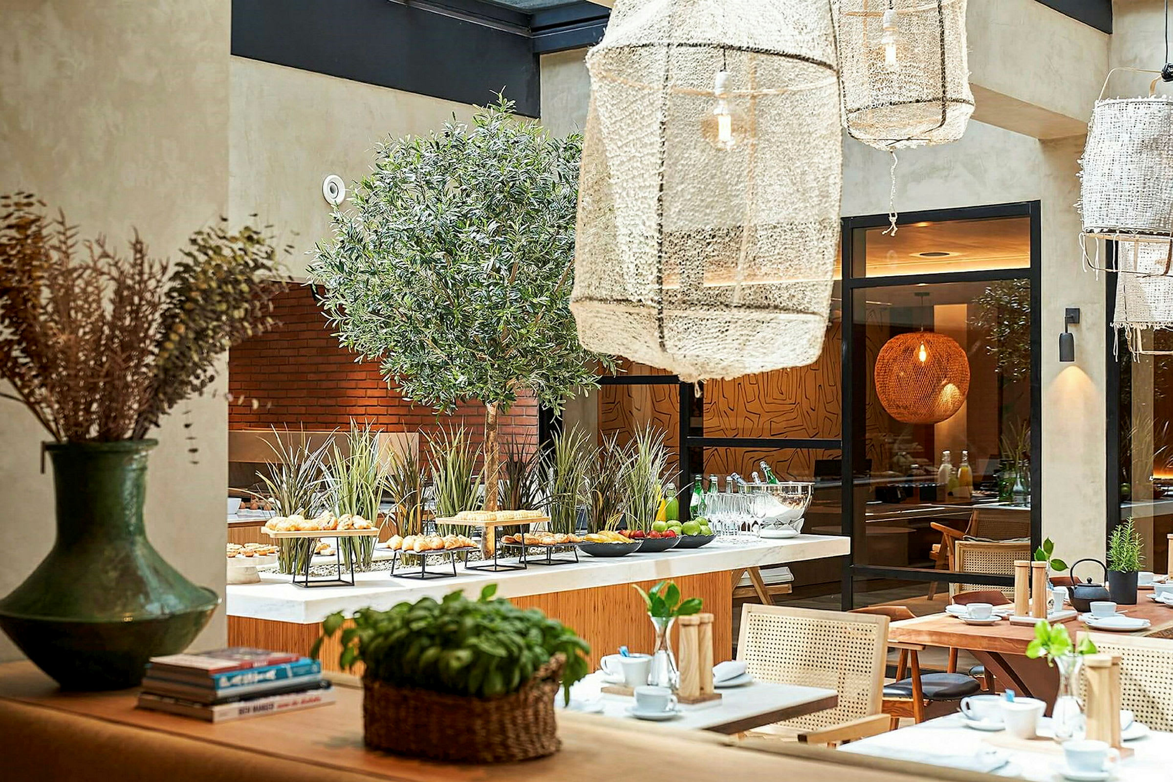 En ljus restauranginteriör med bord, stolar och växtdetaljer. (AI-genererad text)