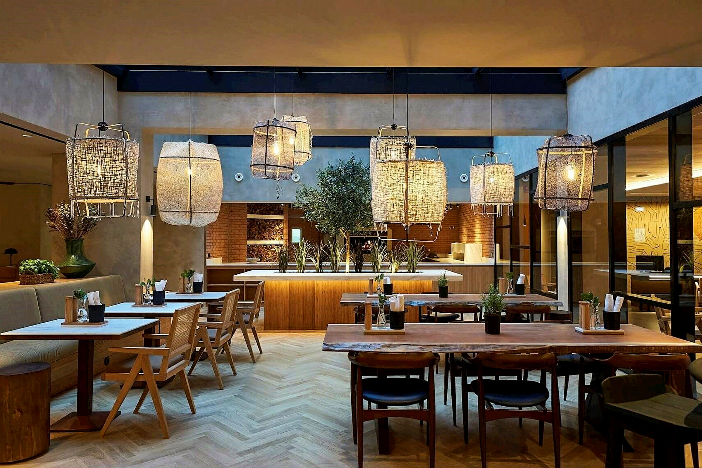 Interiör av en restaurang med träbord, stolar och stora hängande lampor. (AI-genererad text)