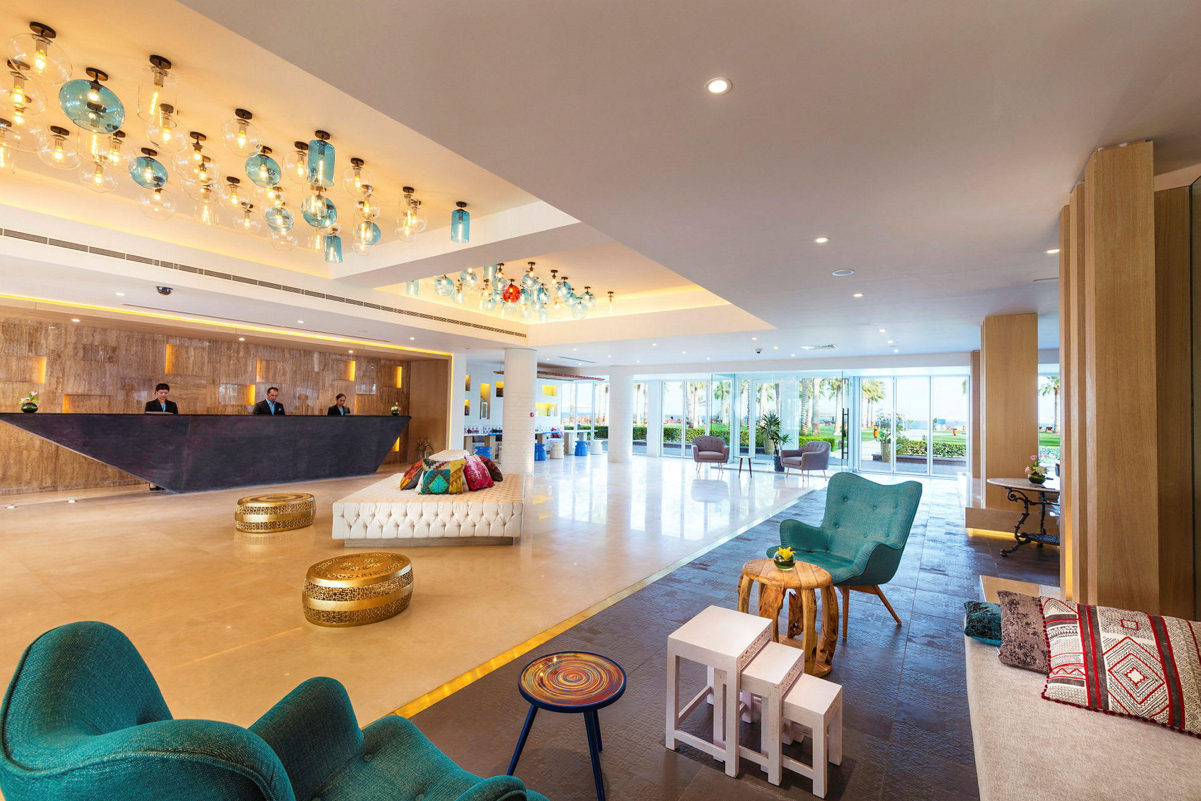 Ett hotellobby med sittplatser, en modern reception och ljus dekoration. (AI-genererad text)