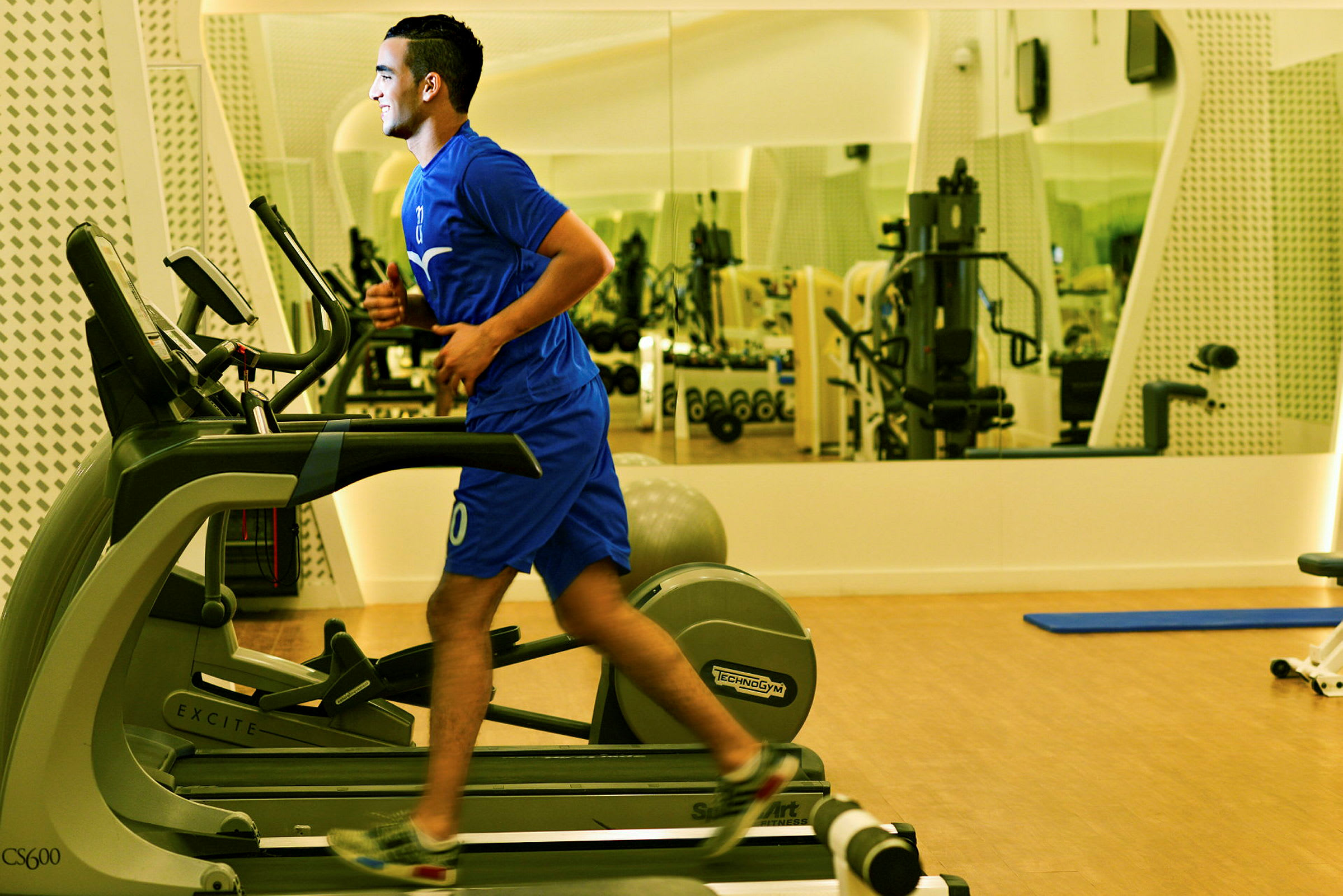 Person tränar på ett löpband i ett gym. (AI-genererad text)