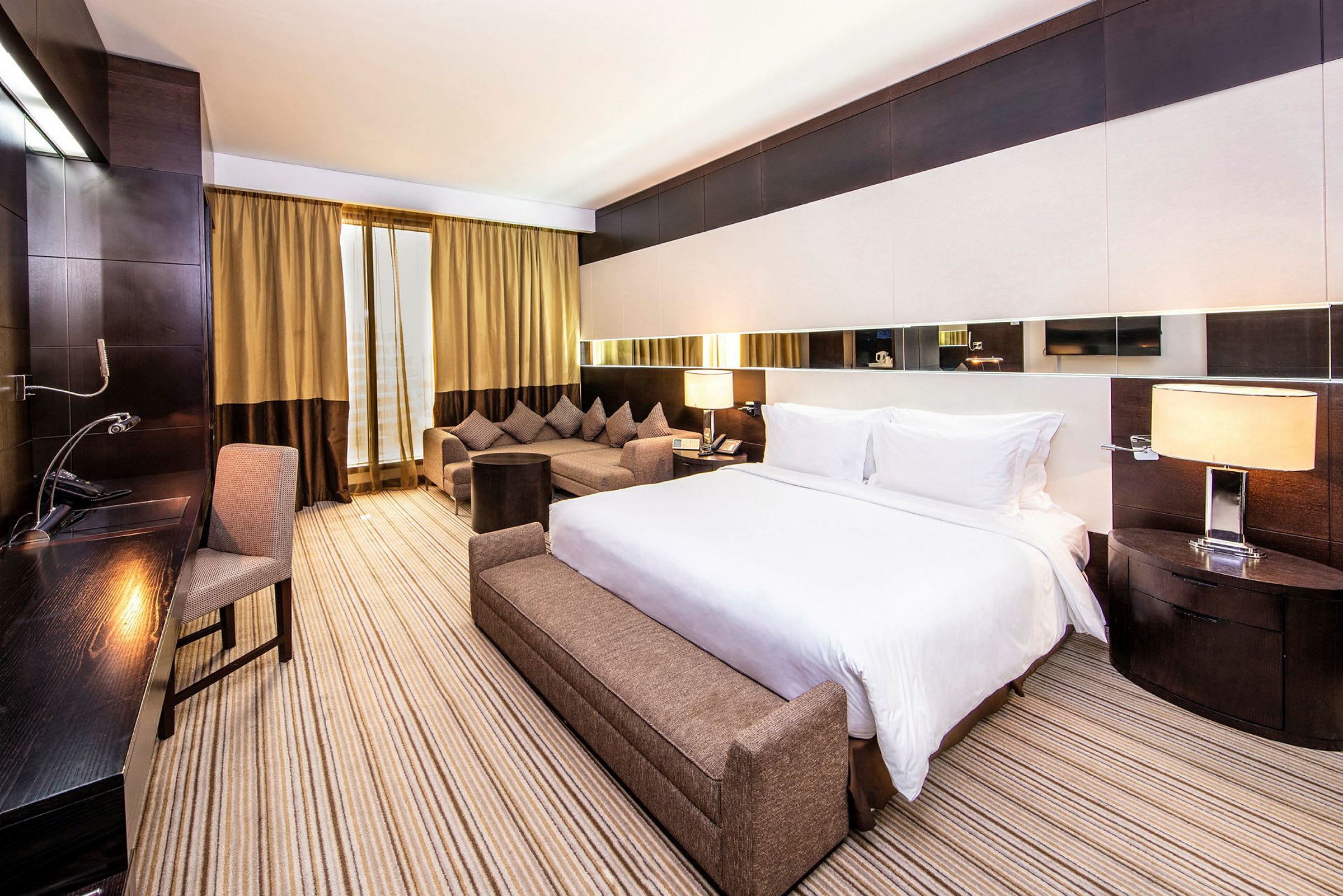 Ett hotellrum med en stor säng, en soffgrupp och ett skrivbord. (AI-genererad text)