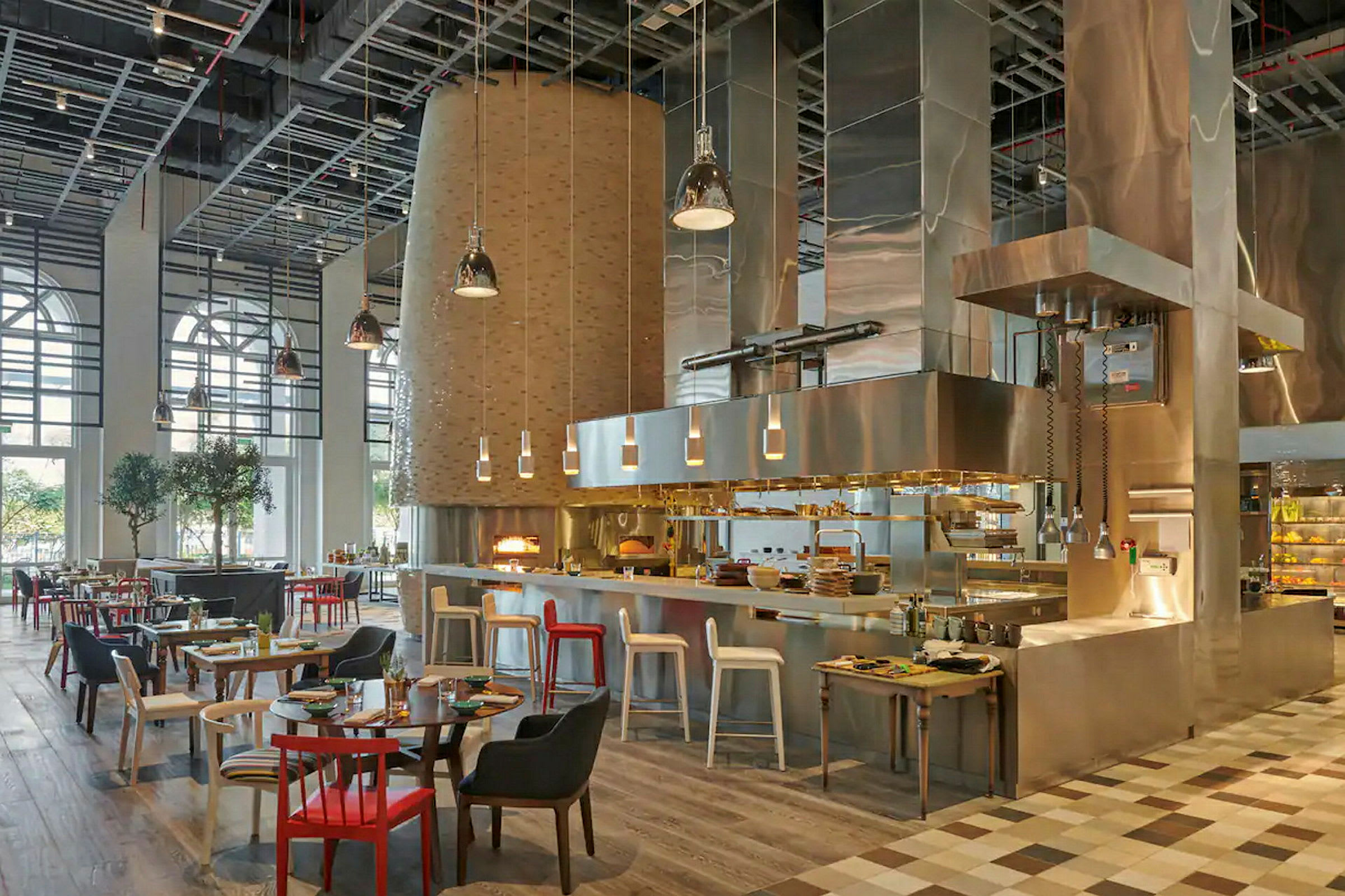 En restaurang med ett öppet kök, modern inredning och sittplatser med olika färger och design. (AI-genererad text)