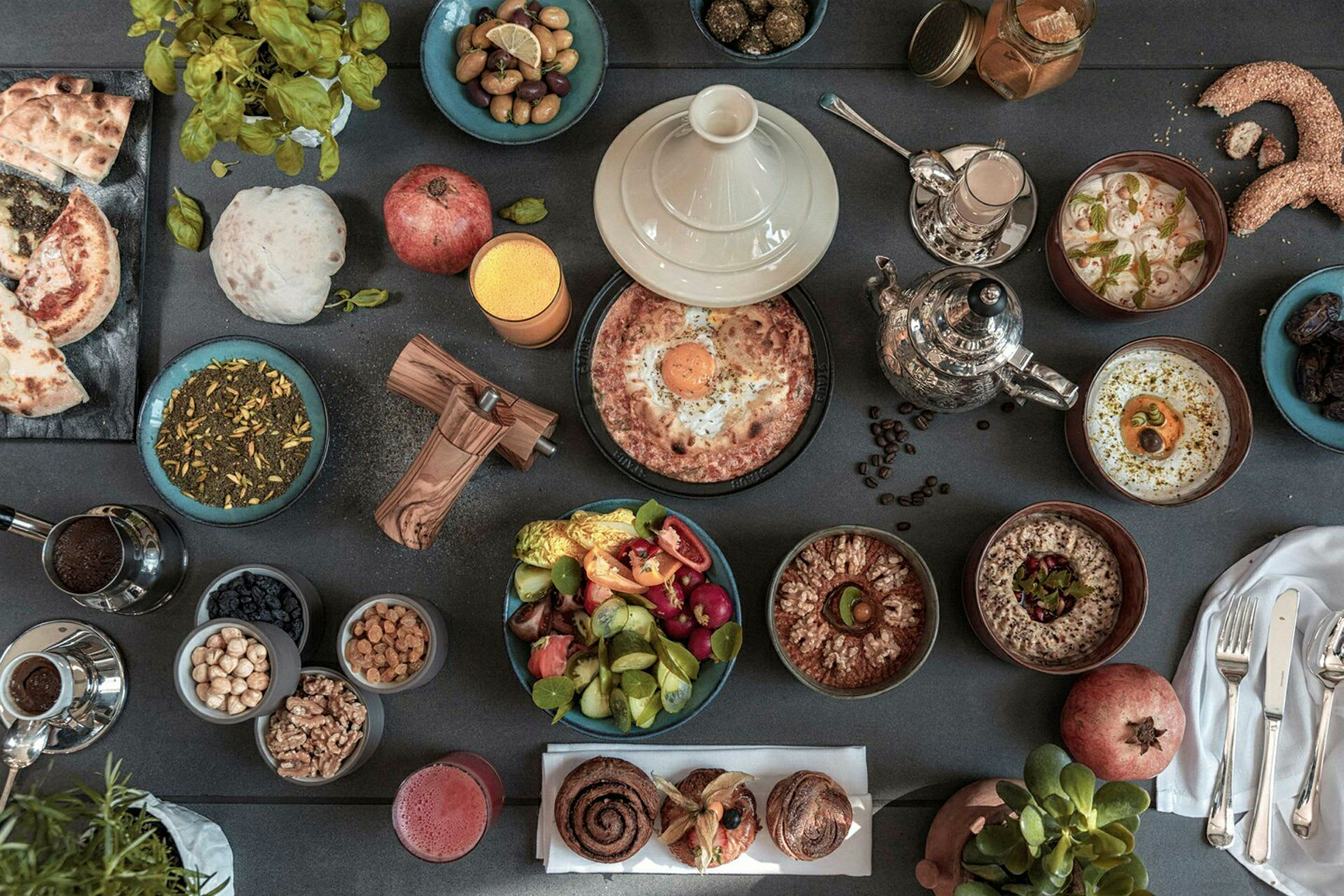 Ett bord fyllt med en variation av mat- och dryckesalternativ, inklusive grönsaker, bakverk och te. (AI-genererad text)