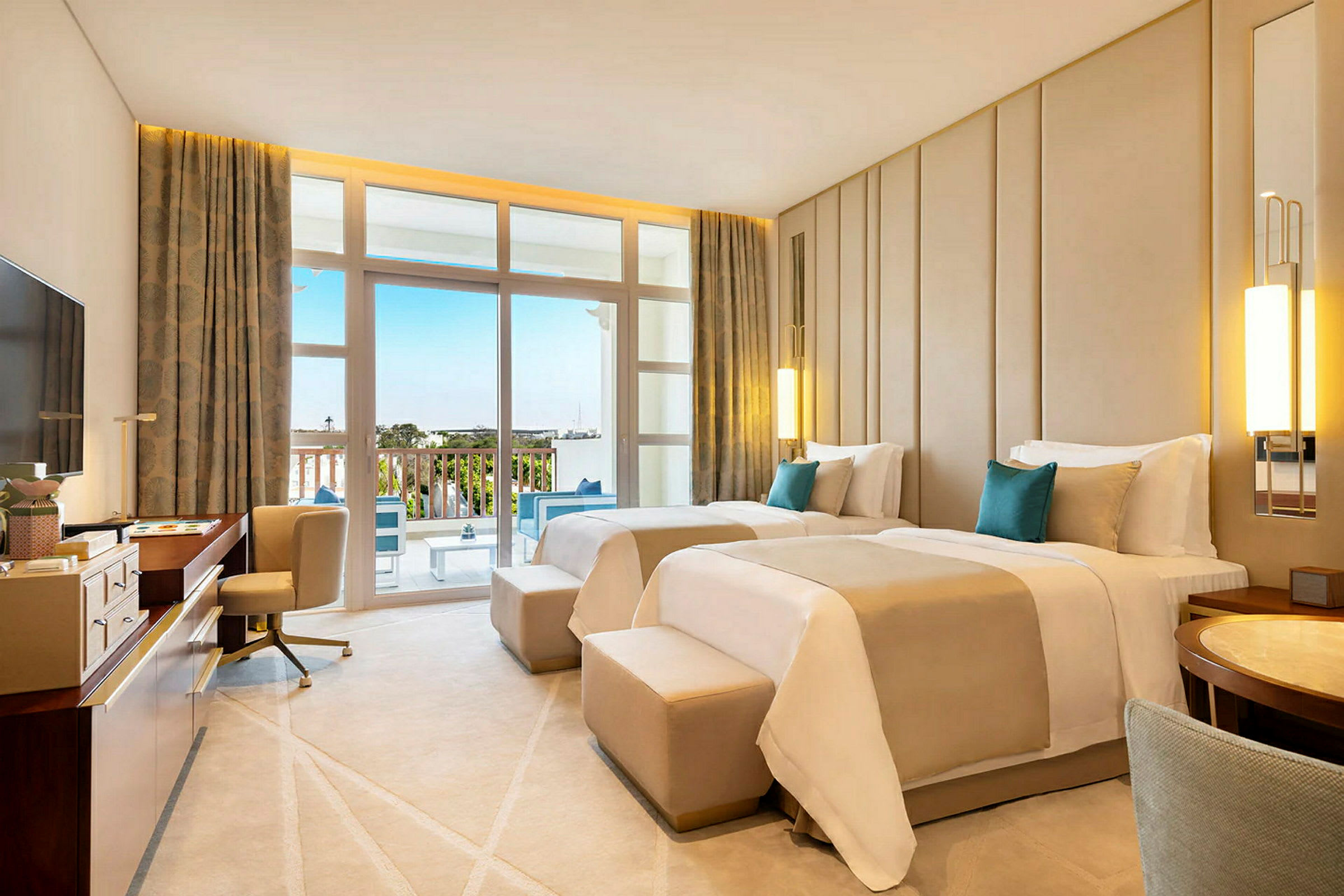 Ett hotellrum med två enkelsängar, skrivbord, fåtölj och balkong med utsikt över omgivningen. (AI-genererad text)