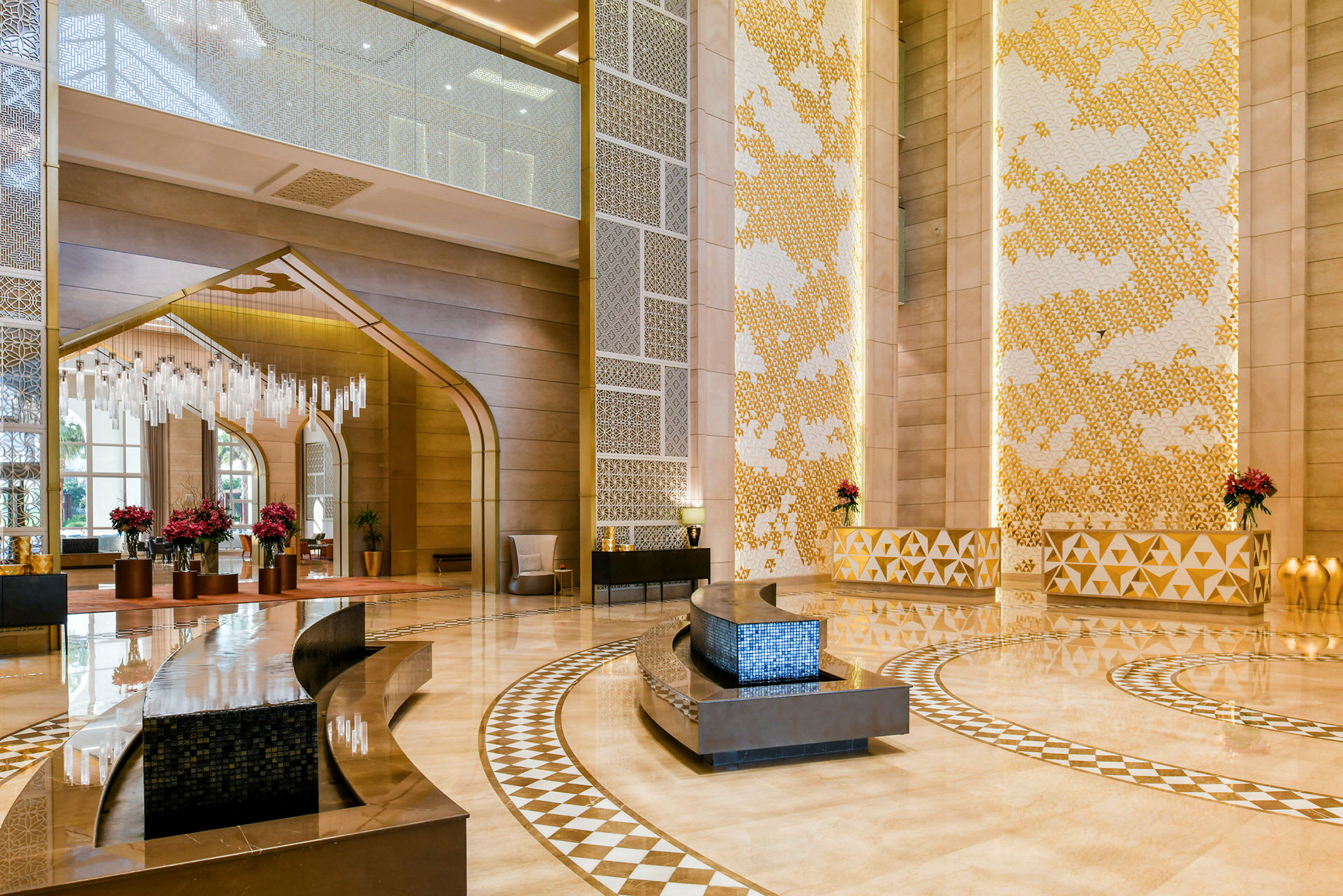 Ett elegant inrett hotellobby med högt i tak, dekorativt mönstrat golv och moderna möbler. (AI-genererad text)