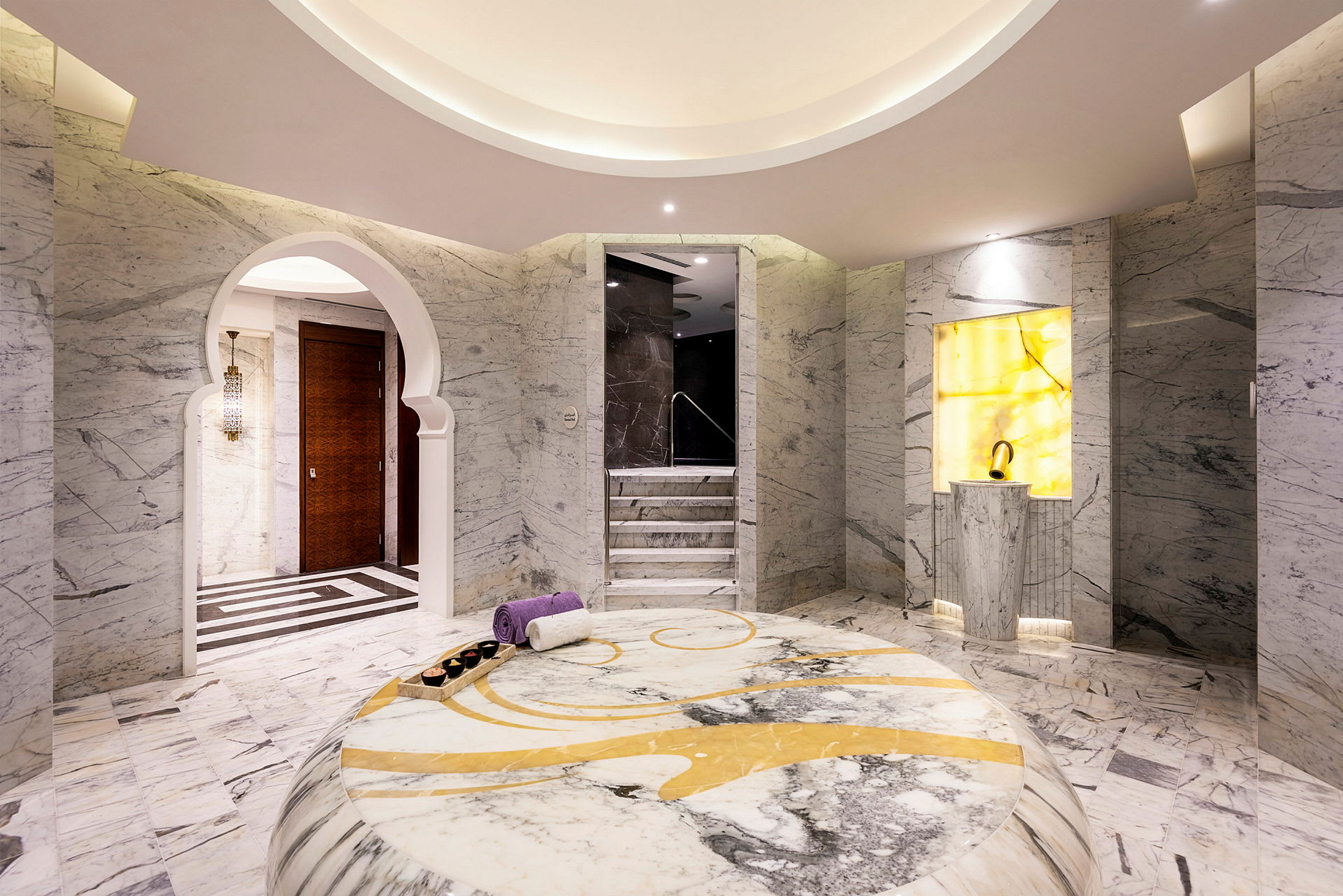 Ett elegant spa- eller badrum med marmordetaljer och en ljusgul accentvägg. (AI-genererad text)