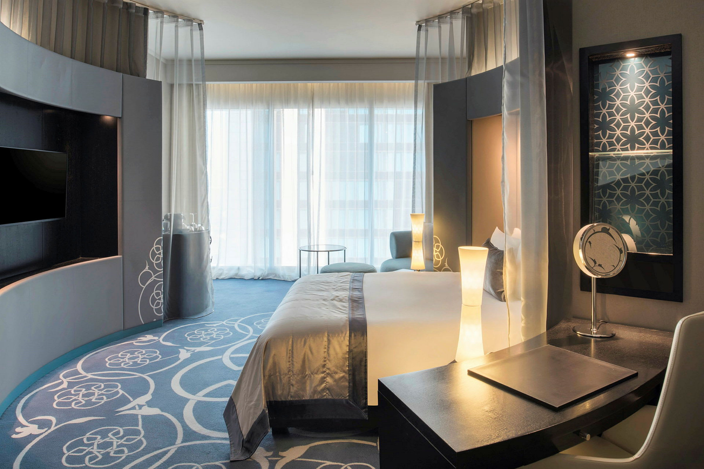 Hotellrum med modern inredning, säng och skrivbord. (AI-genererad text)