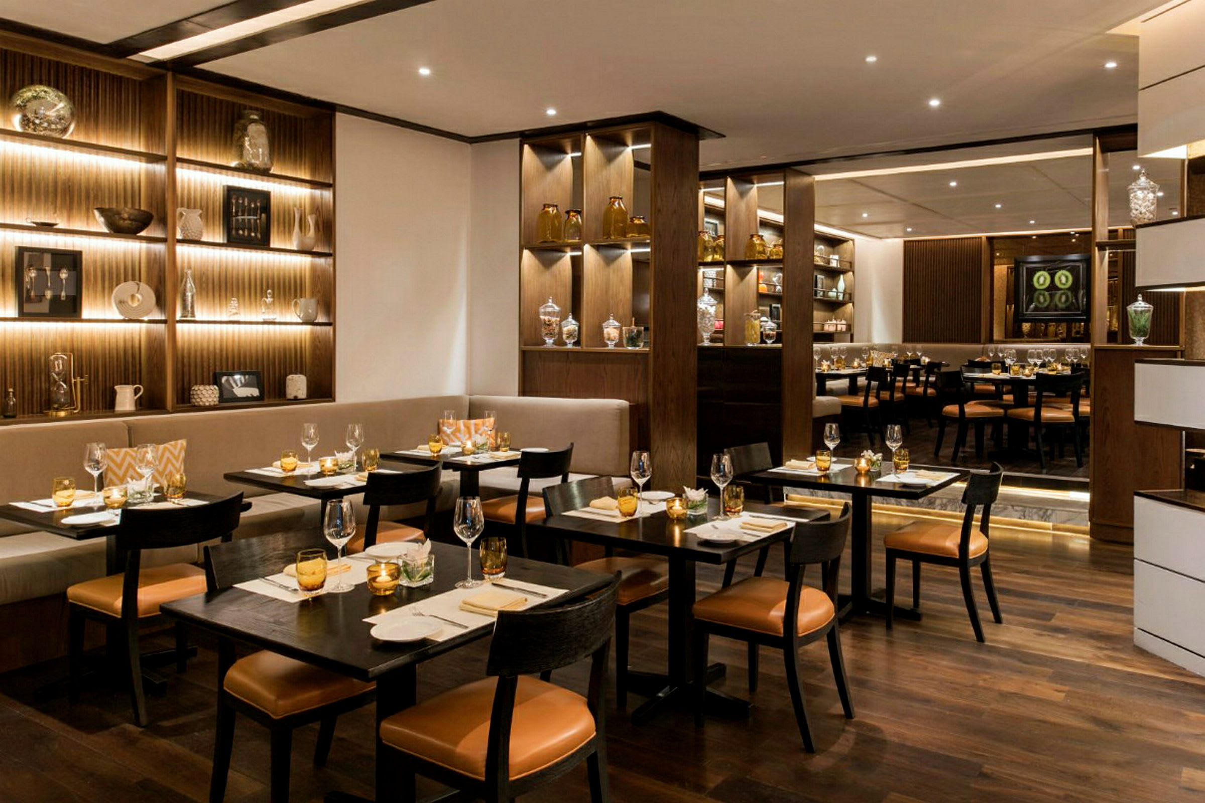 En elegant restaurang med bord, stolar och välutrustade hyllor. (AI-genererad text)