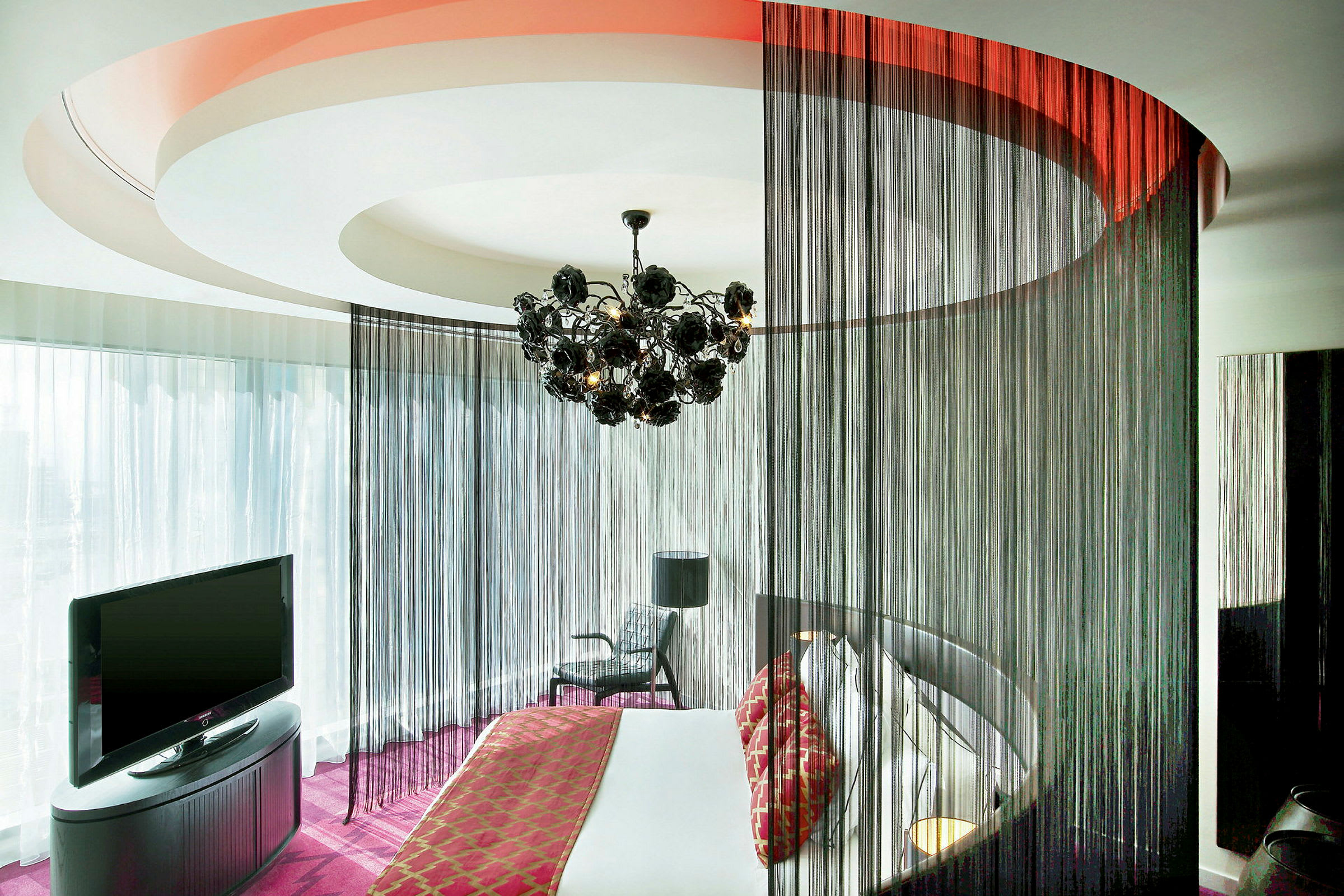 Hotellrum med modern inredning, rund säng, tv och dekorativ belysning. (AI-genererad text)