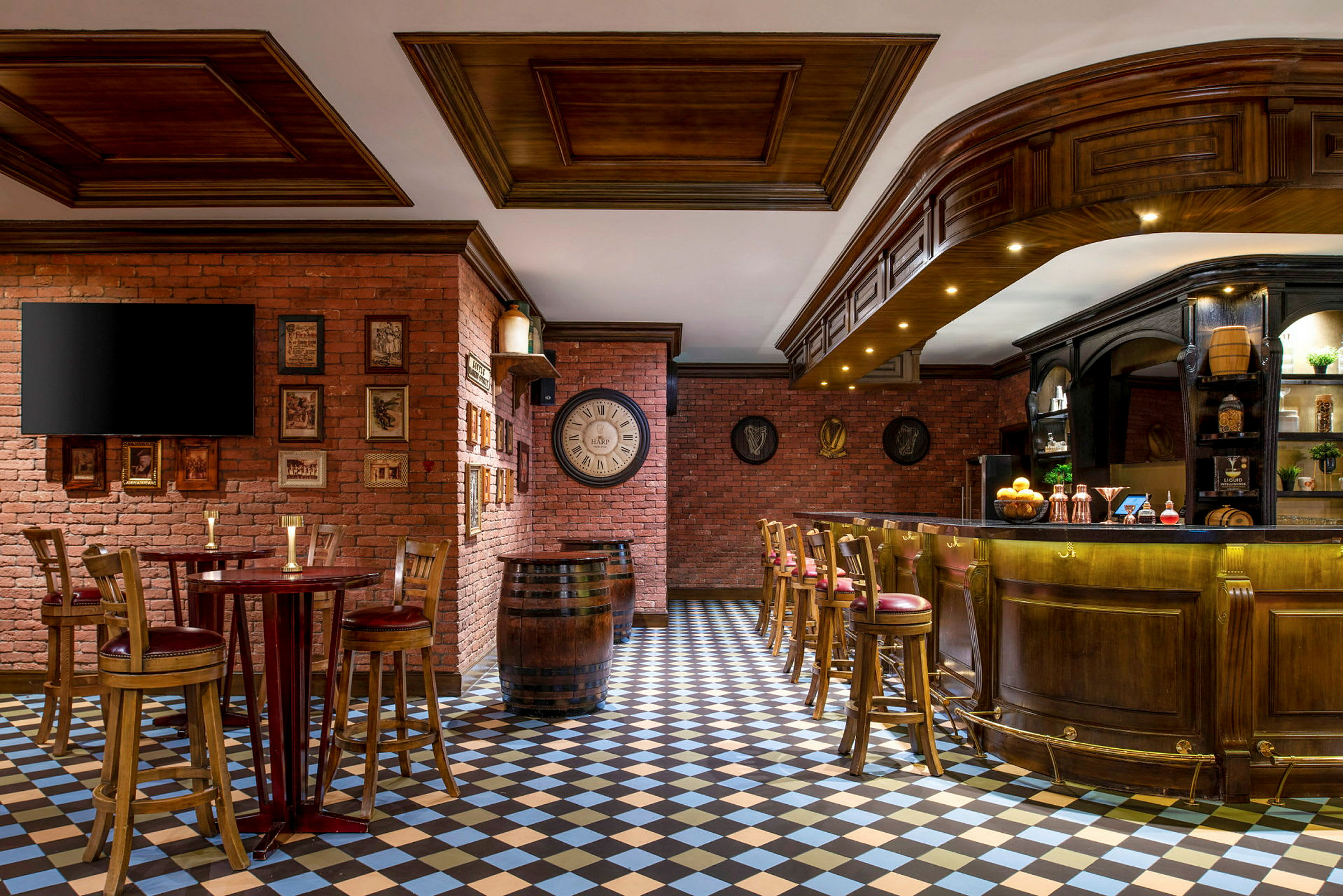 En inomhusmiljö med en bar och sittplatser, omgiven av tegelväggar och ett rutigt golv. (AI-genererad text)