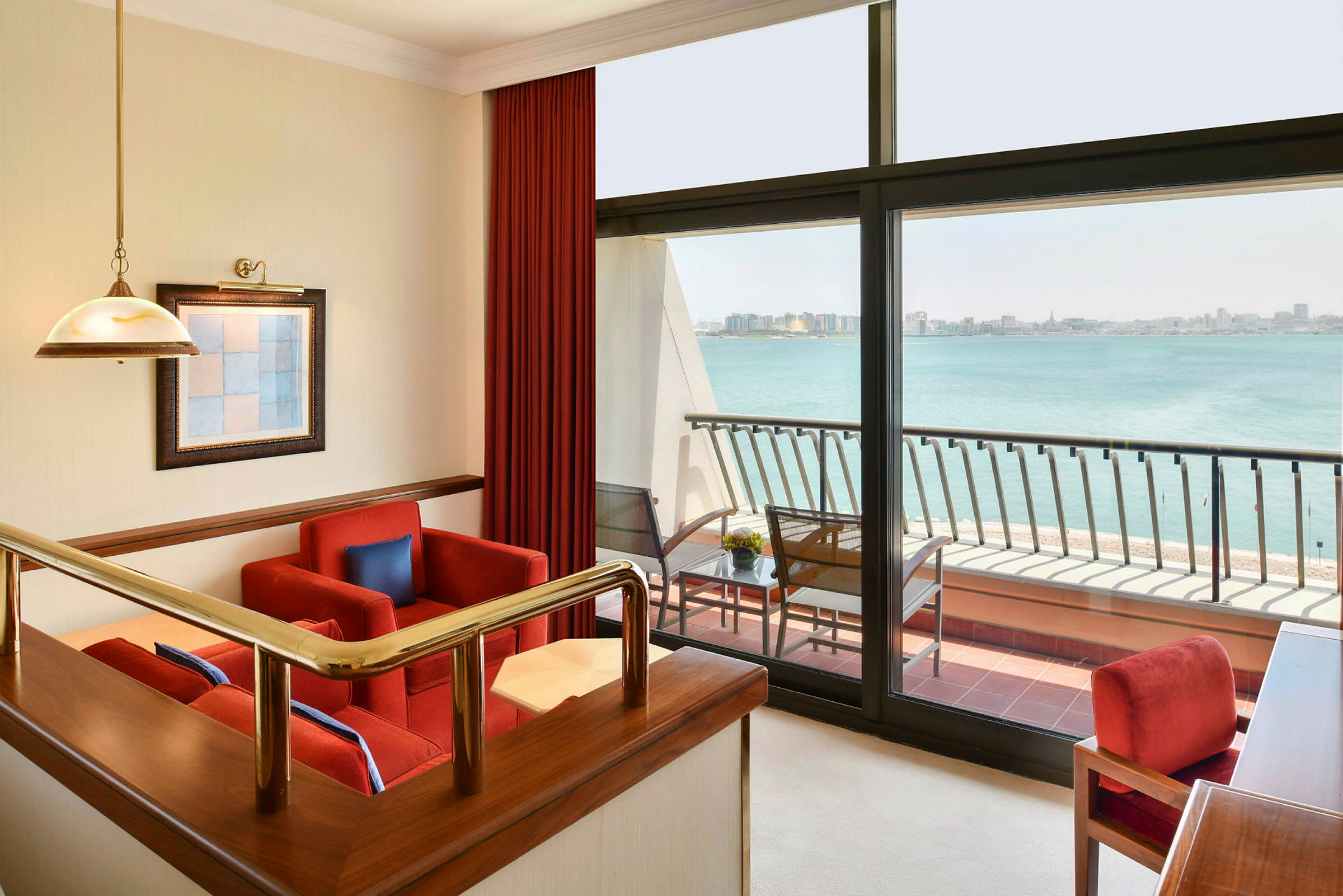 En modern hotellsvit med sittgrupp, stora fönster och utsikt över havet. (AI-genererad text)