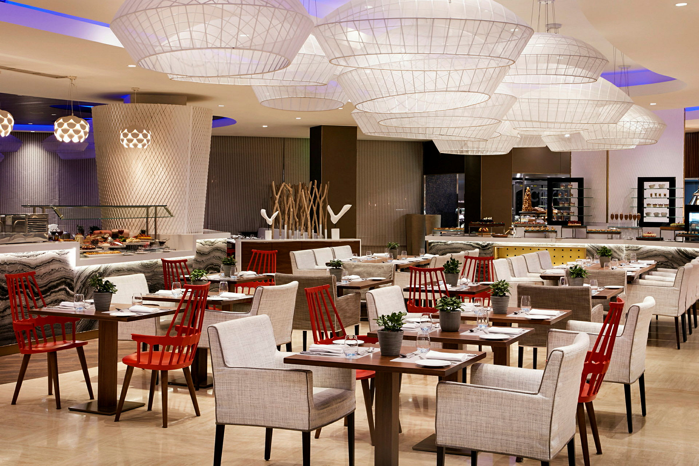 Ett elegant inrett restaurangområde med moderna möbler och dekorativ belysning. (AI-genererad text)