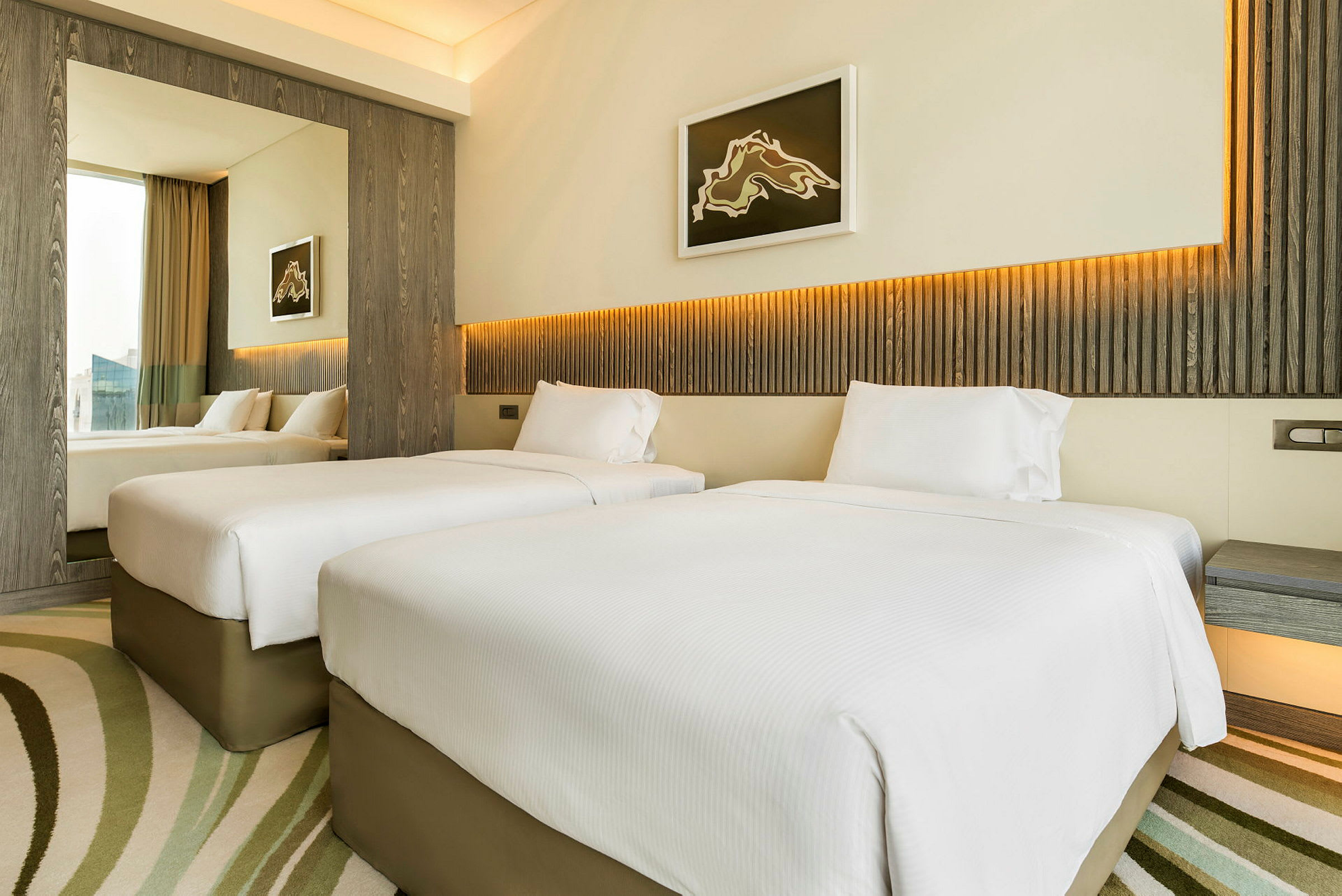 Hotellrum med två enkelsängar, modern inredning och ljusa färger. (AI-genererad text)
