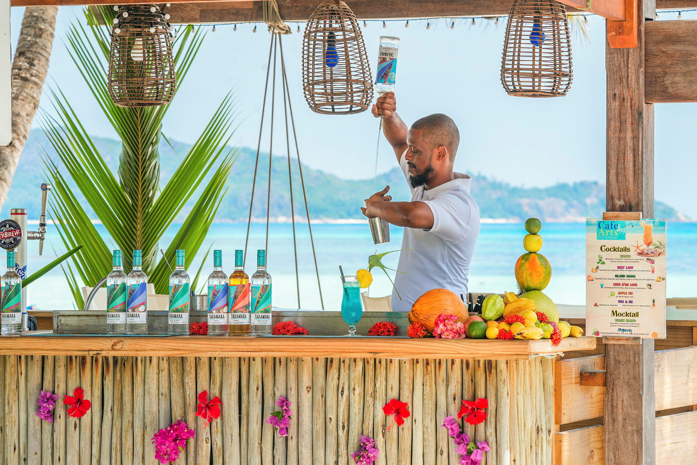 En strandbar dekorerad med blommor där cocktails tillreds. (AI-genererad text)