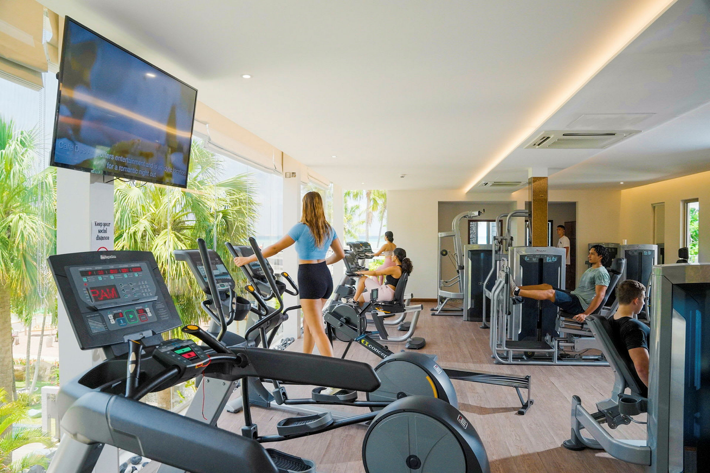 Ett modernt gym med träningsutrustning och personer som tränar. (AI-genererad text)