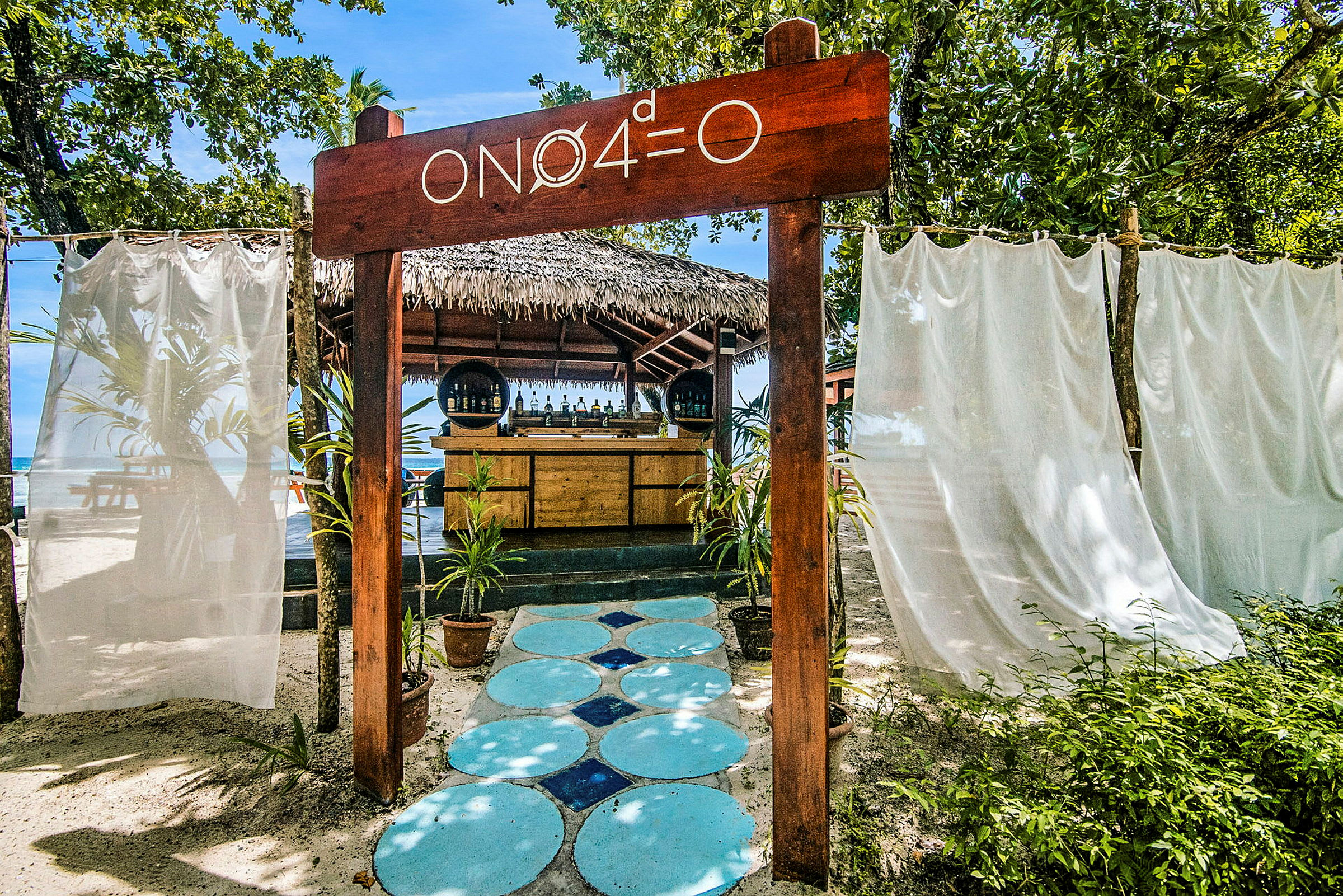 Strandbar med skylt och omgivande växtlighet. (AI-genererad text)
