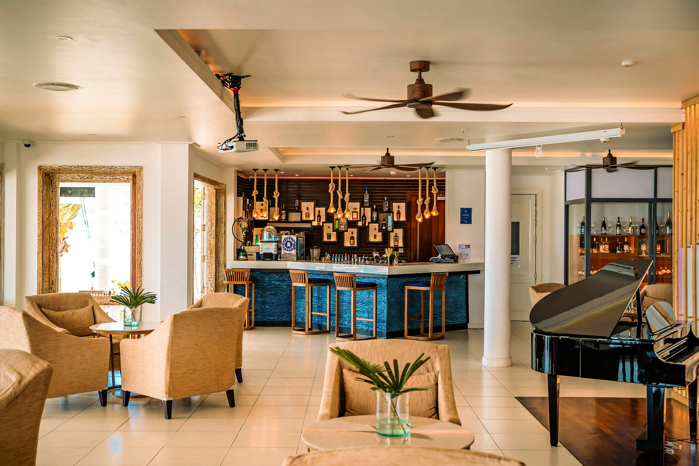 Hotellobby med sittplatser, bar och svart piano. (AI-genererad text)