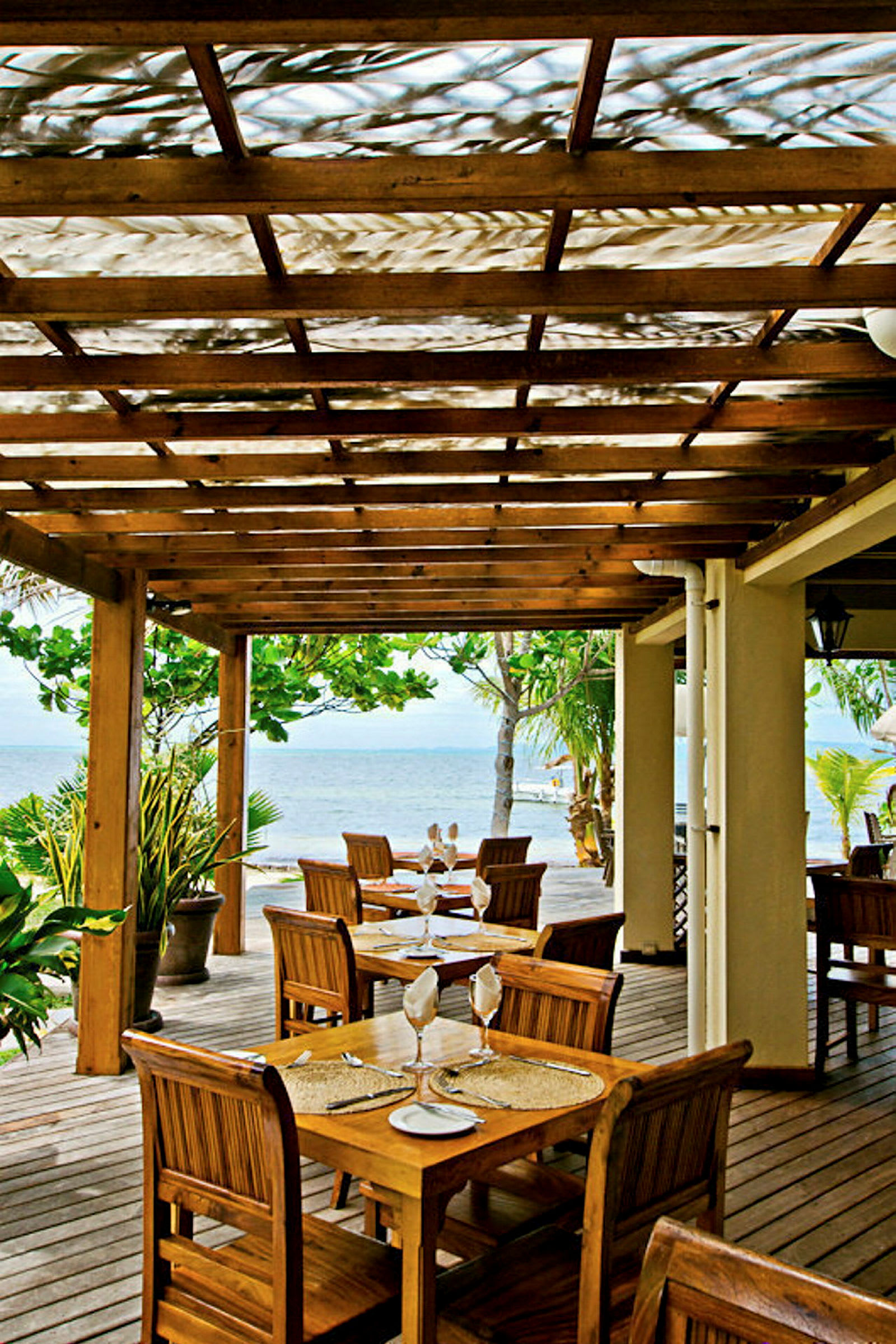 Restaurangterrass med trämöbler med utsikt över havet. (AI-genererad text)
