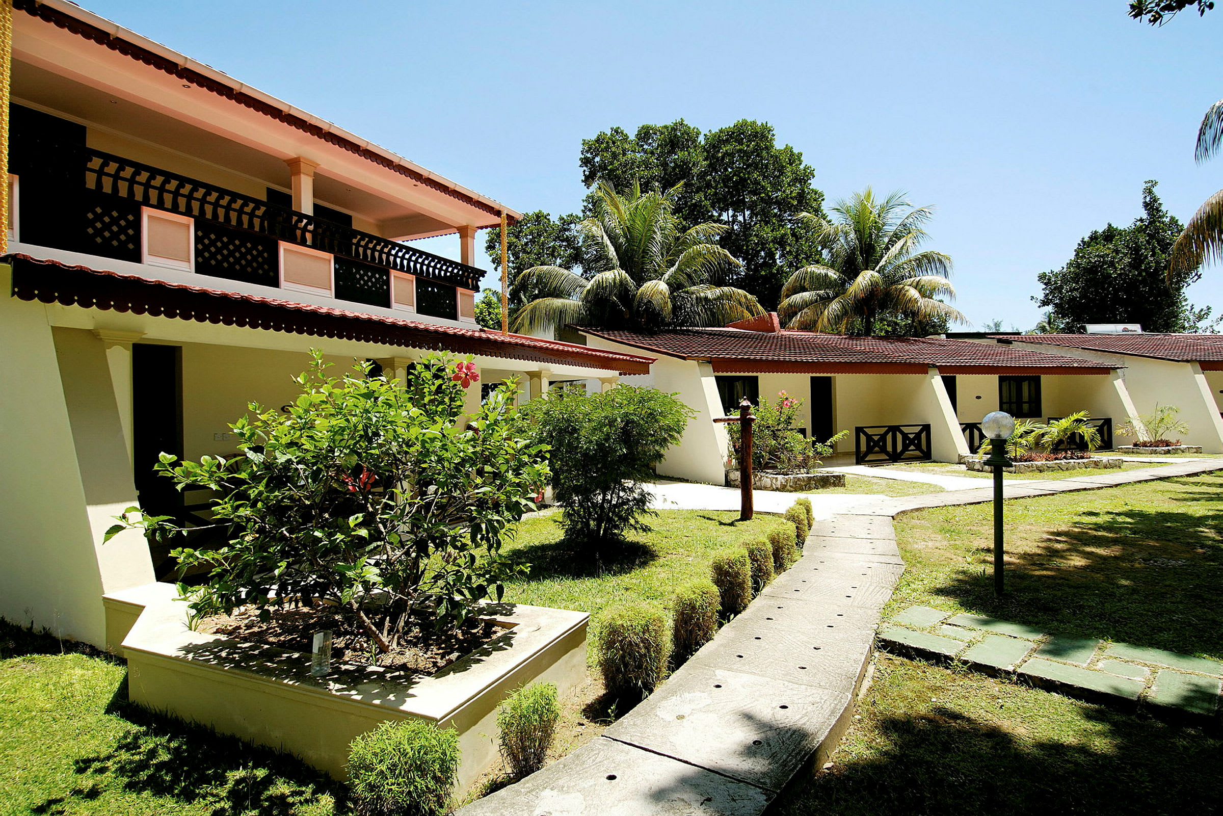 Exteriör av byggnad med trädgård och gångväg. (AI-genererad text)
