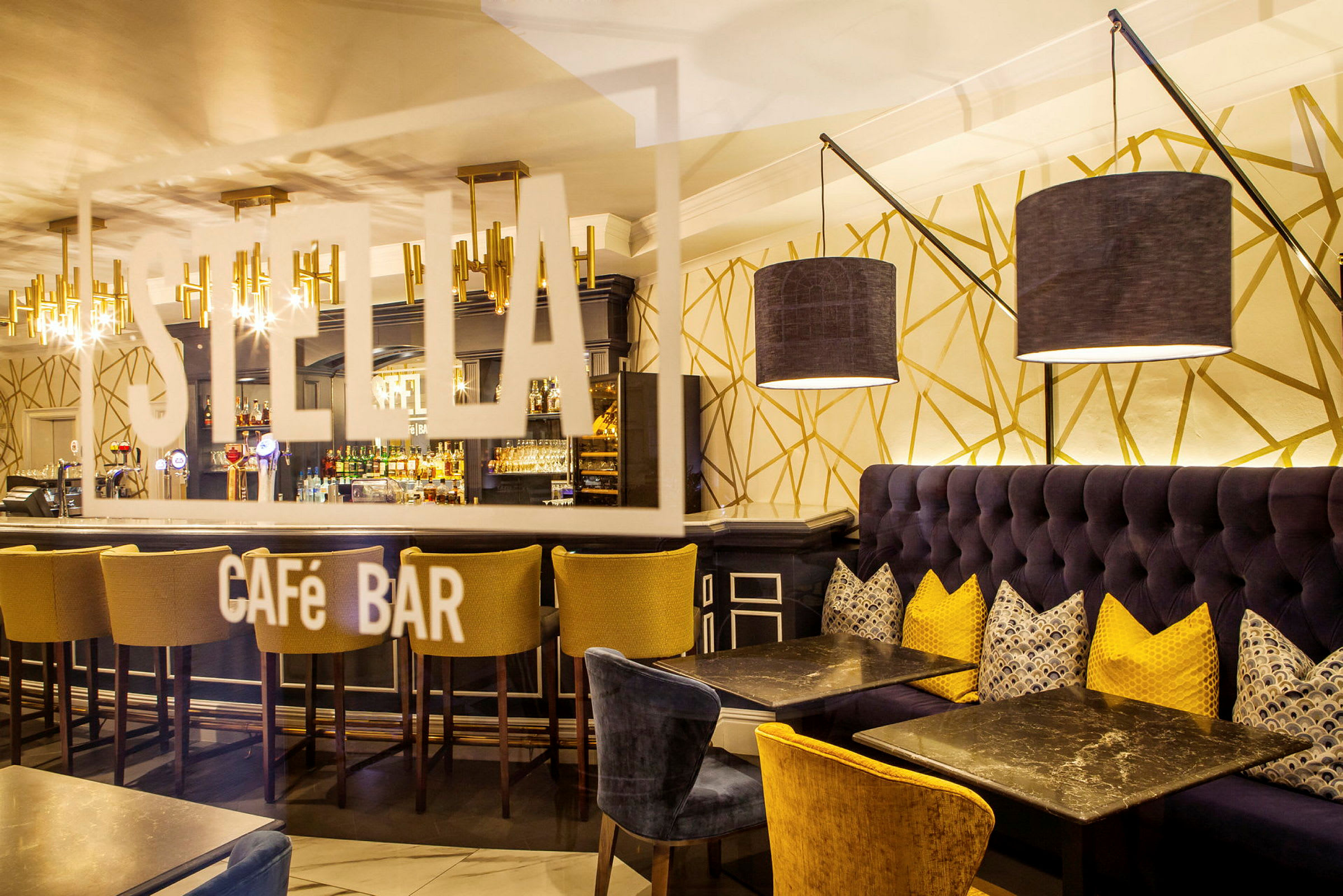 Interiör av ett stilfullt cafébar med soffor, bord och en bardisk. (AI-genererad text)