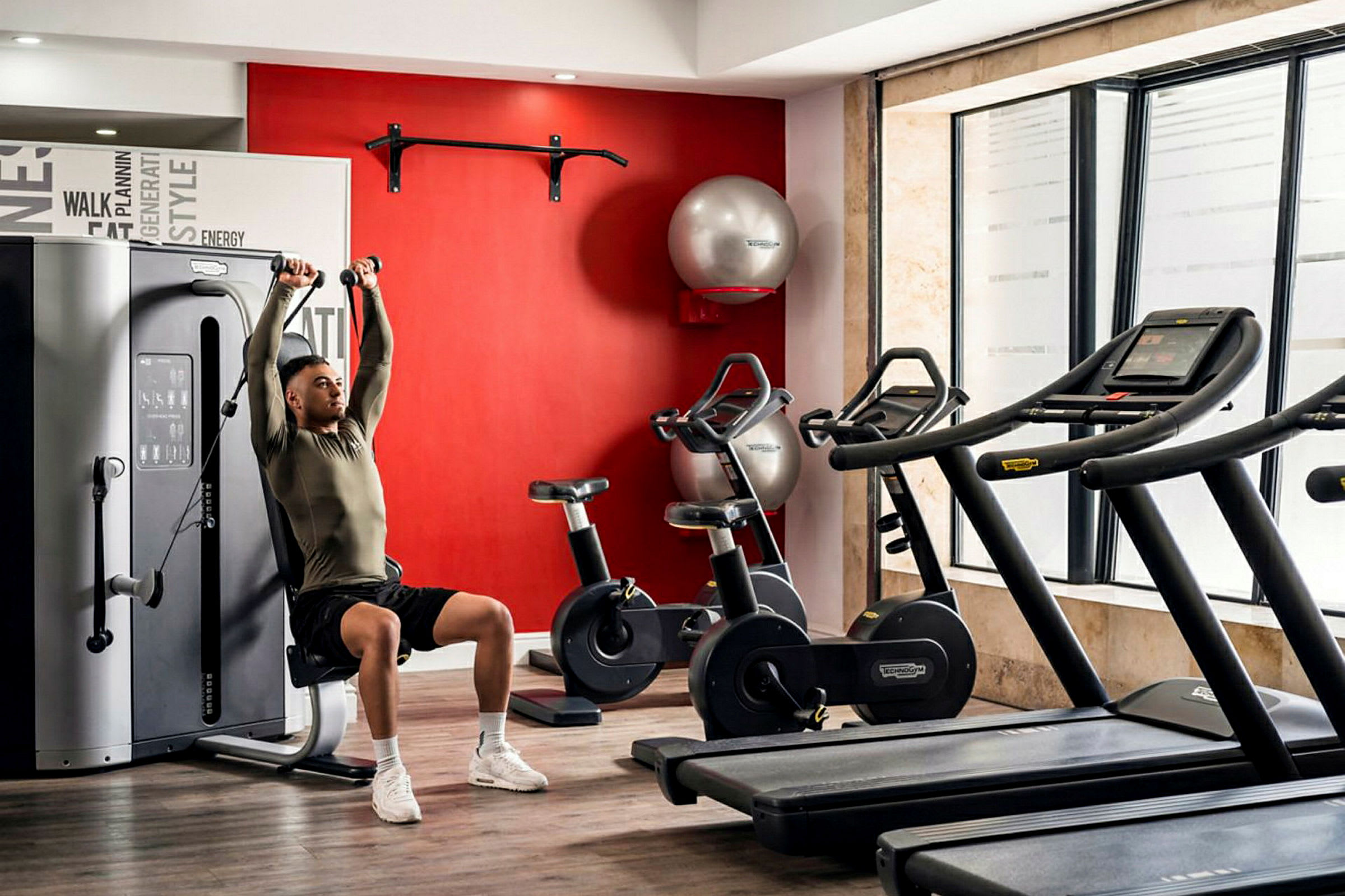 Ett gym med träningsmaskiner, konditionscyklar och löpband. (AI-genererad text)
