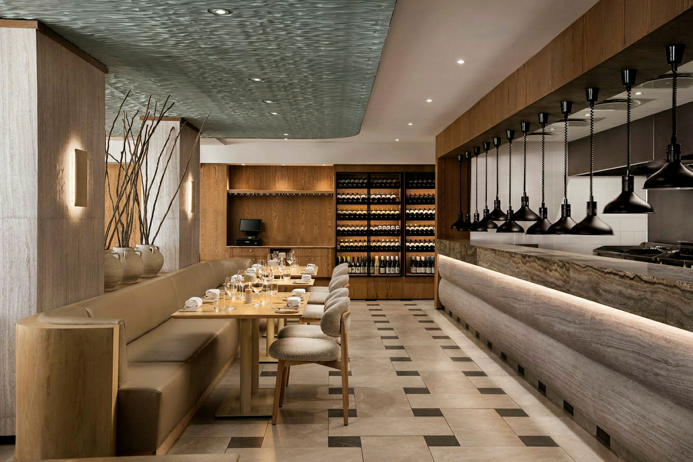 Interiör av en elegant restaurang med sittplatser, bord och en öppen köksdel. (AI-genererad text)