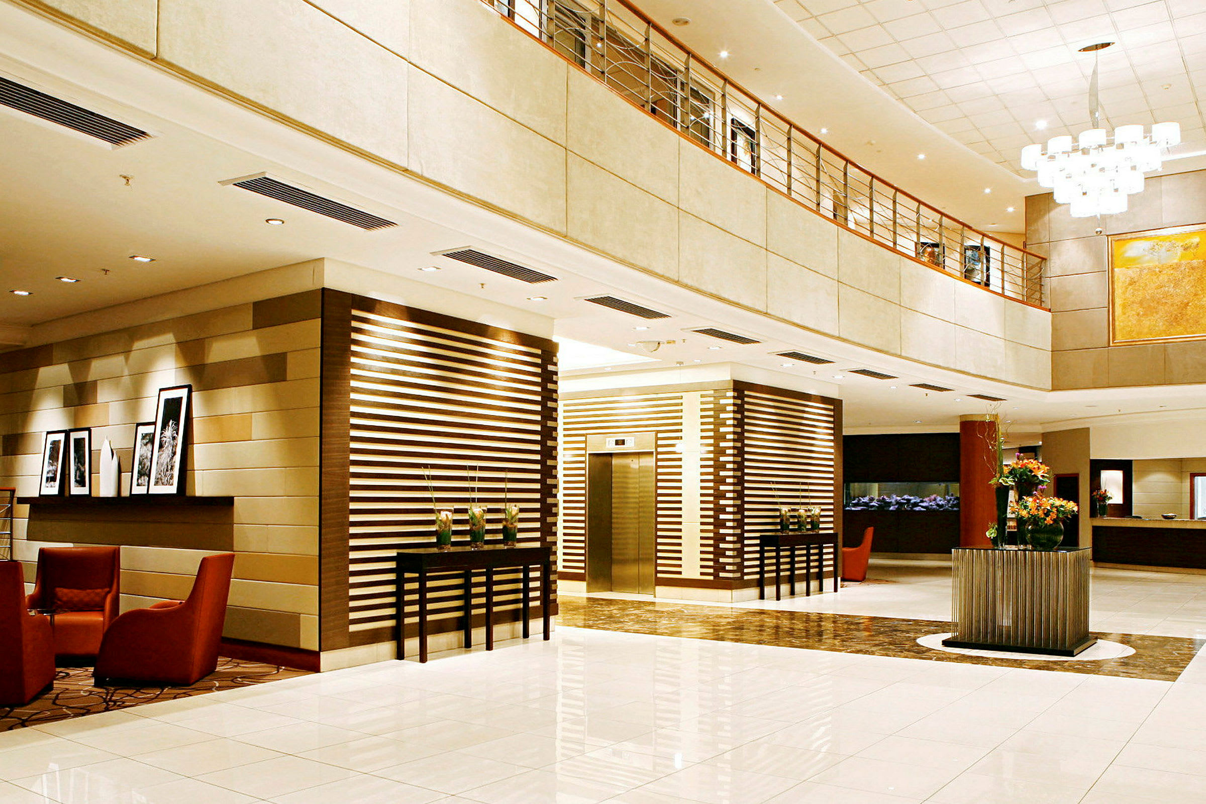 En elegant hotellobby med ljus inredning, sittplatser och en hiss. (AI-genererad text)