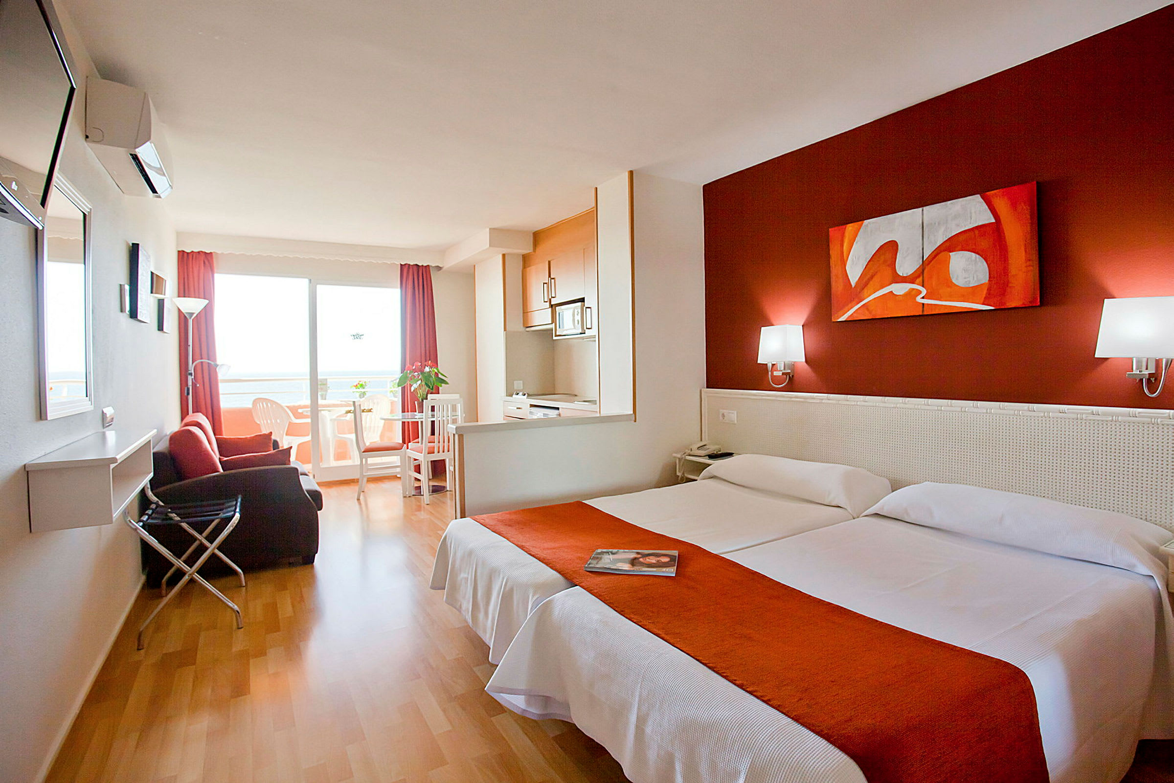 Hotellrum med två enkelsängar, sittgrupp och balkong. (AI-genererad text)